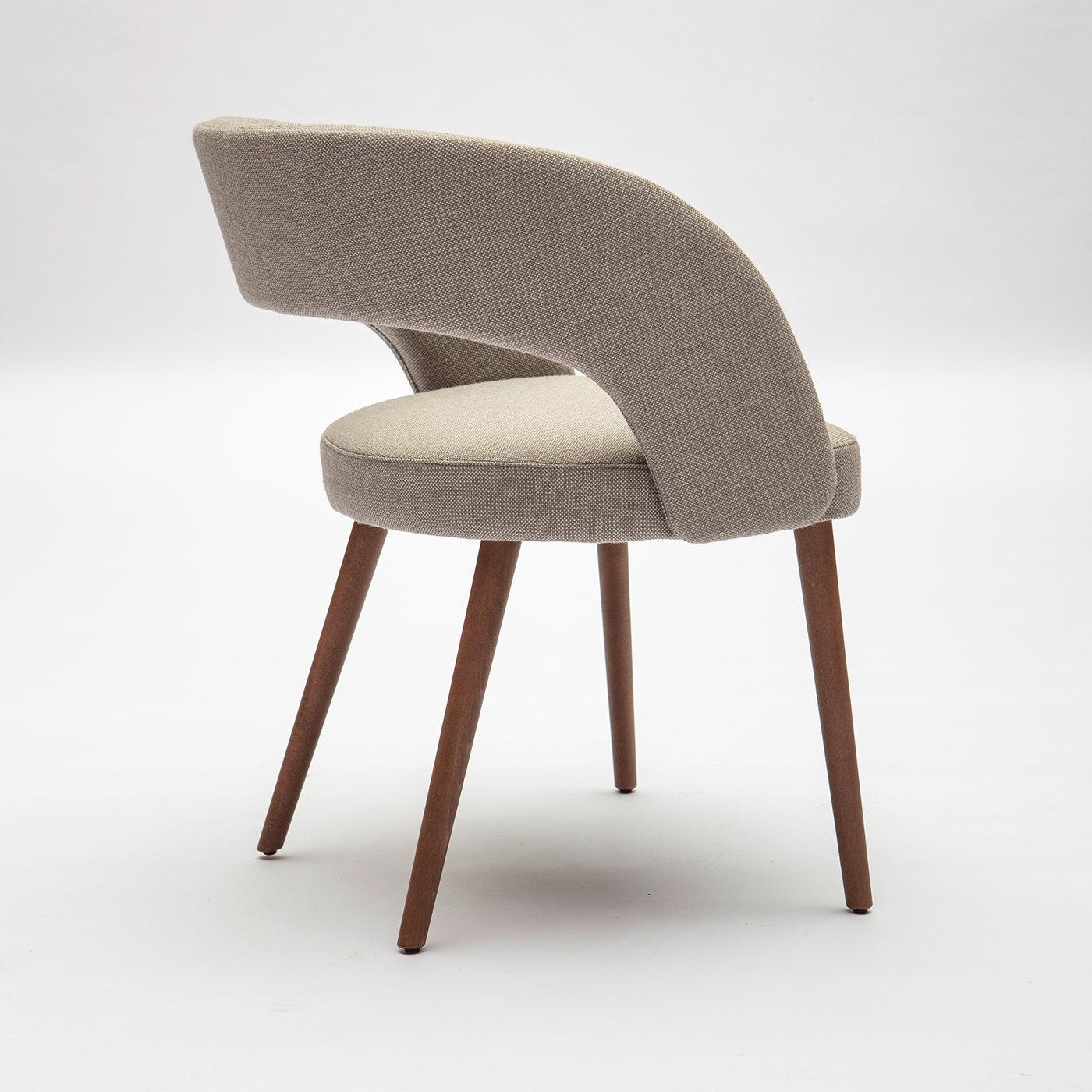 Mit seiner Kombination aus Retro-Formen und modernen Oberflächen strahlt der Ring-Stuhl Raffinesse aus. Im Einklang mit der Wiederbelebung des Midcentury Modern, ruht der Stuhl auf runden, ausgestellten Beinen aus massivem Buchenholz. Die