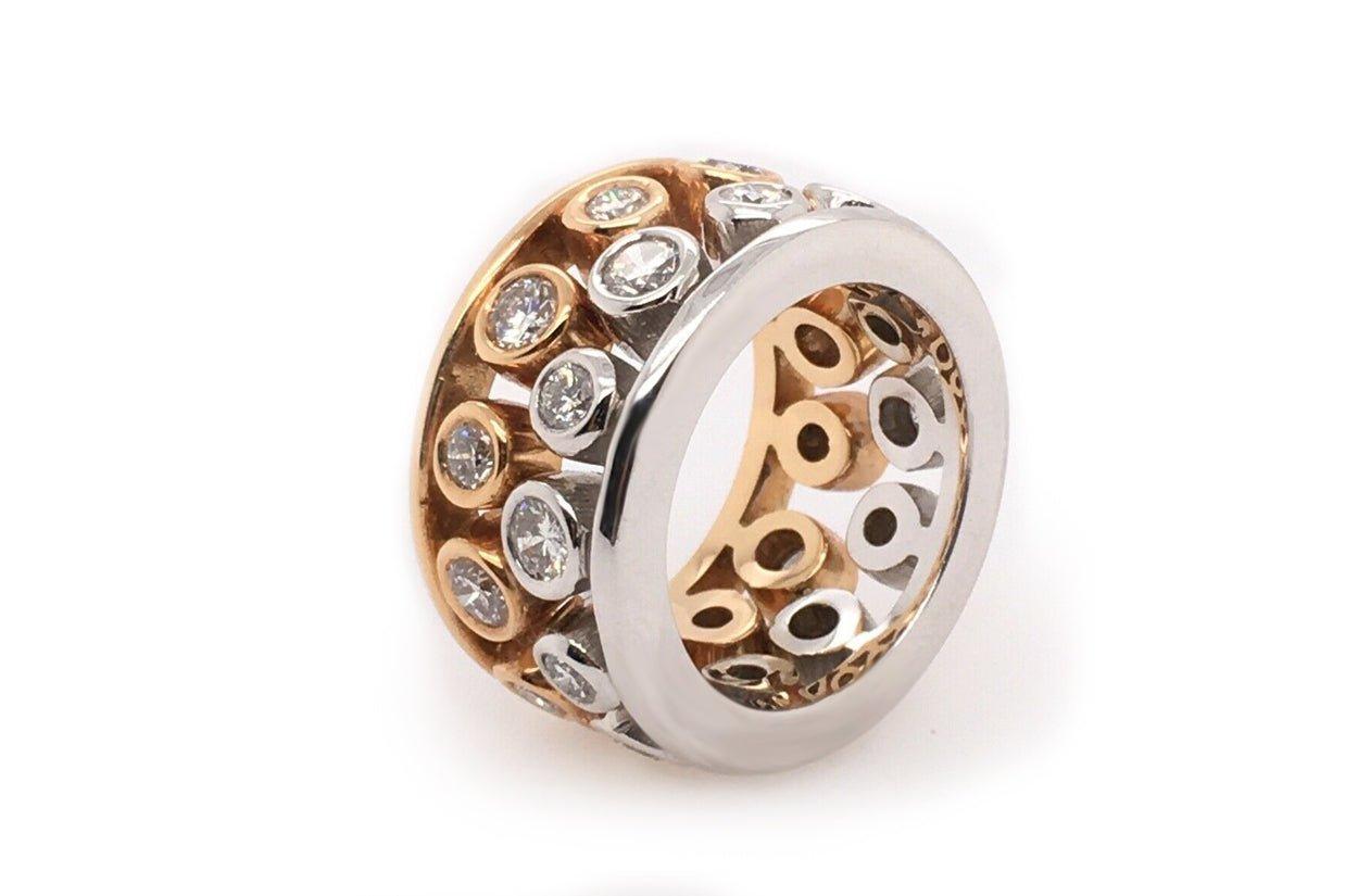 the two-tone 18kt gold ring features natural round diamonds set in bezel settings, creating and elegant and time less design that combines the beauty of both white and yellow gold with the brilliance of diamonds. This type of setting offers a secure