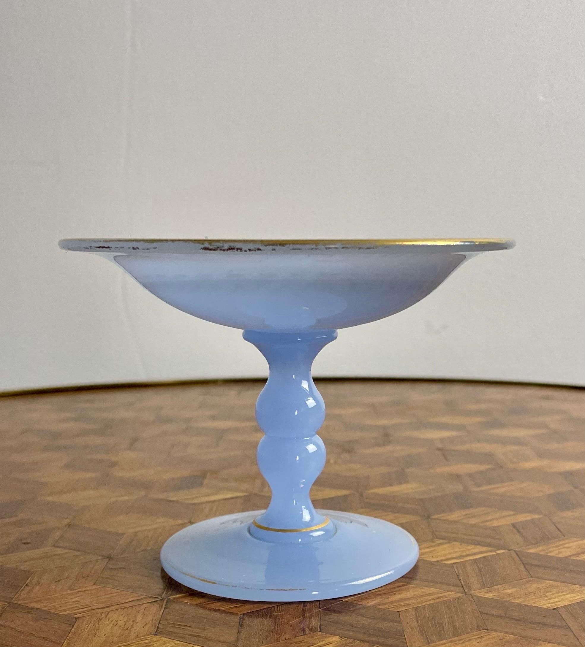 Elegant ring holder or videpoche from the Napoleon III period.
The ring holder is in blue opaline enhanced with several golden edgings on the foot. The cup is illustrated with golden geometric shapes (note a small erasure of certain patterns). The