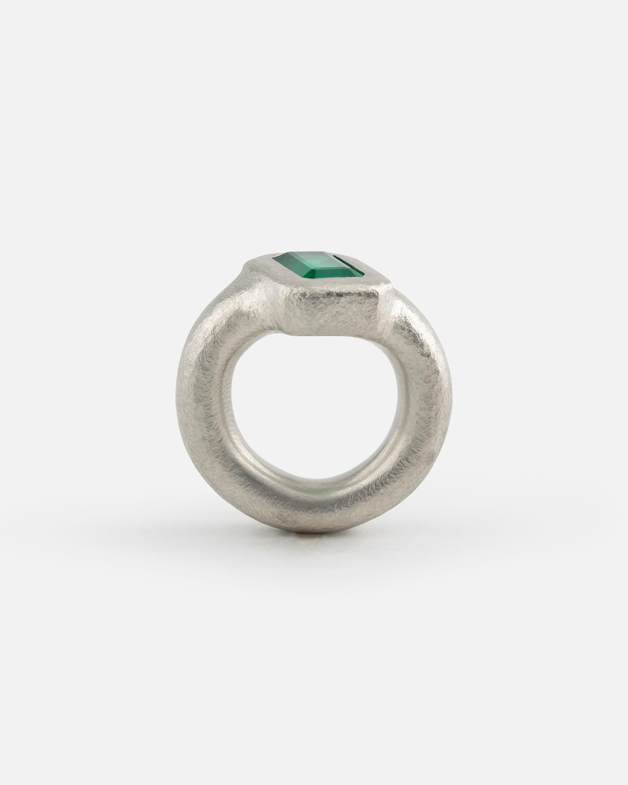 This ring is made of solid platinum and has a big emerald (3.95 ct) in the middle, which is sitting oblique. The surface is hammered matt. Made by Lisa Scherebnenko, a contemporary german jewellery artist.