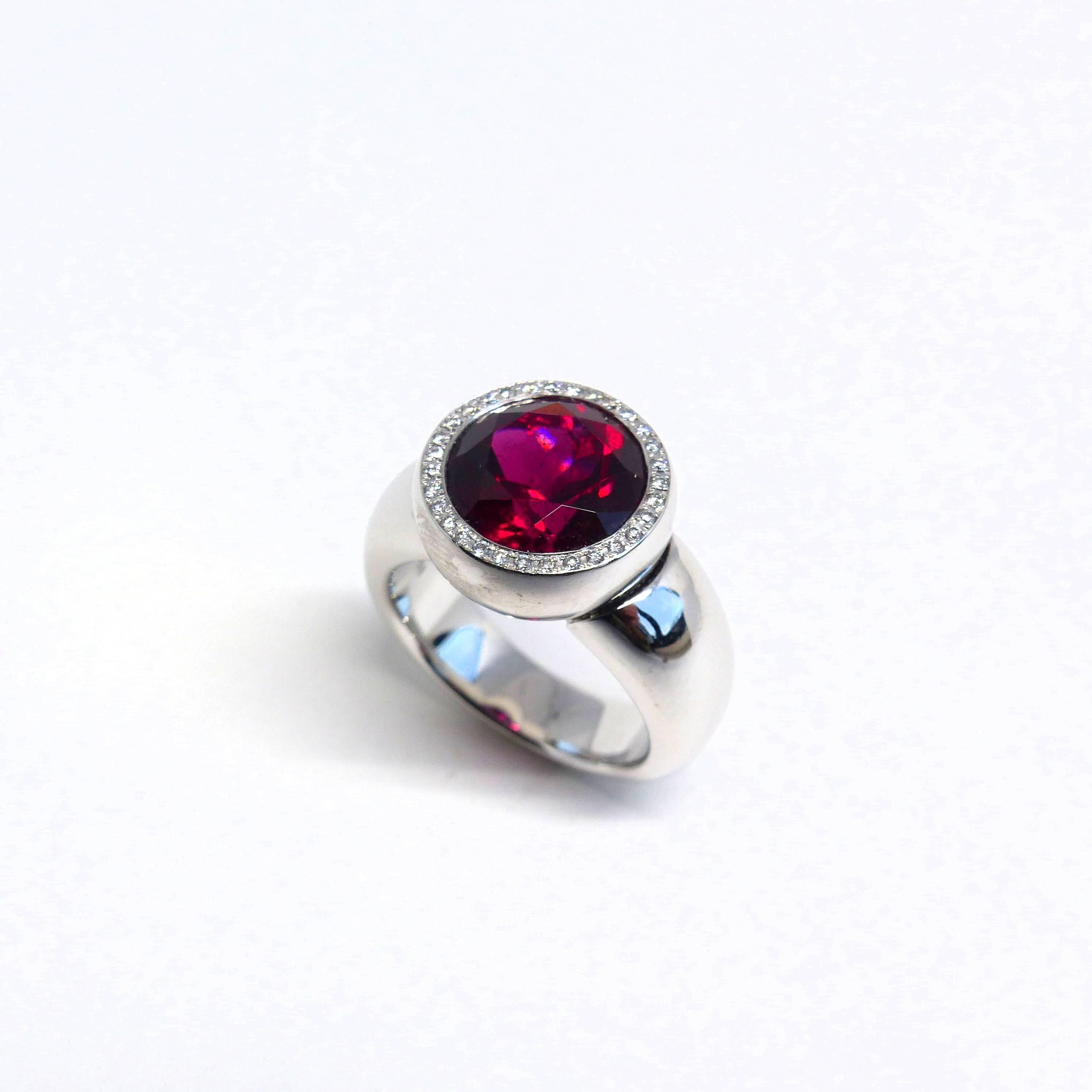 Thomas Leyser is renowned for his contemporary jewellery designs utilizing fine gemstones. 

This 18k white gold 21,25gr. ring with 1x top-quality Rubelite (facetted, round, 11mm, 5,13cts.) + 31x Diamonds (brillant-cut, round, 1mm, 0,25cts.) G (VS).