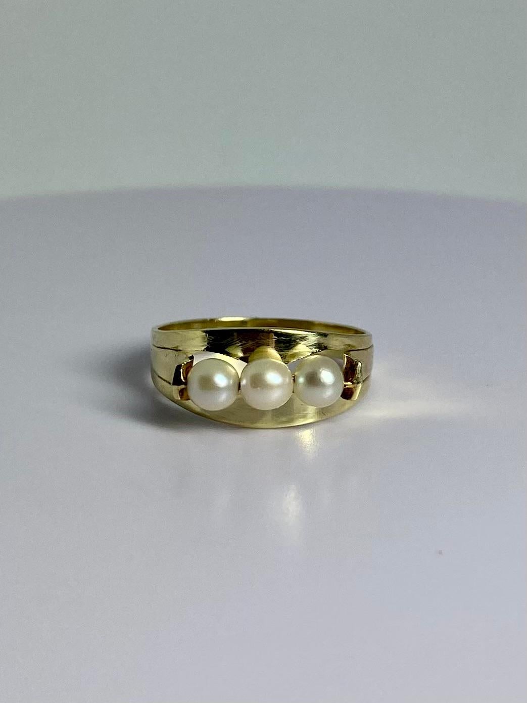 This is something else, elegant & refined. This preloved jewel is made of 14 carat yellow gold and is set with 3 white round pearls. The pearls are set in an open setting. Weighs about 2.5 grams and has ring size 6 1/2 (US), N (UK) 17 (EU). This