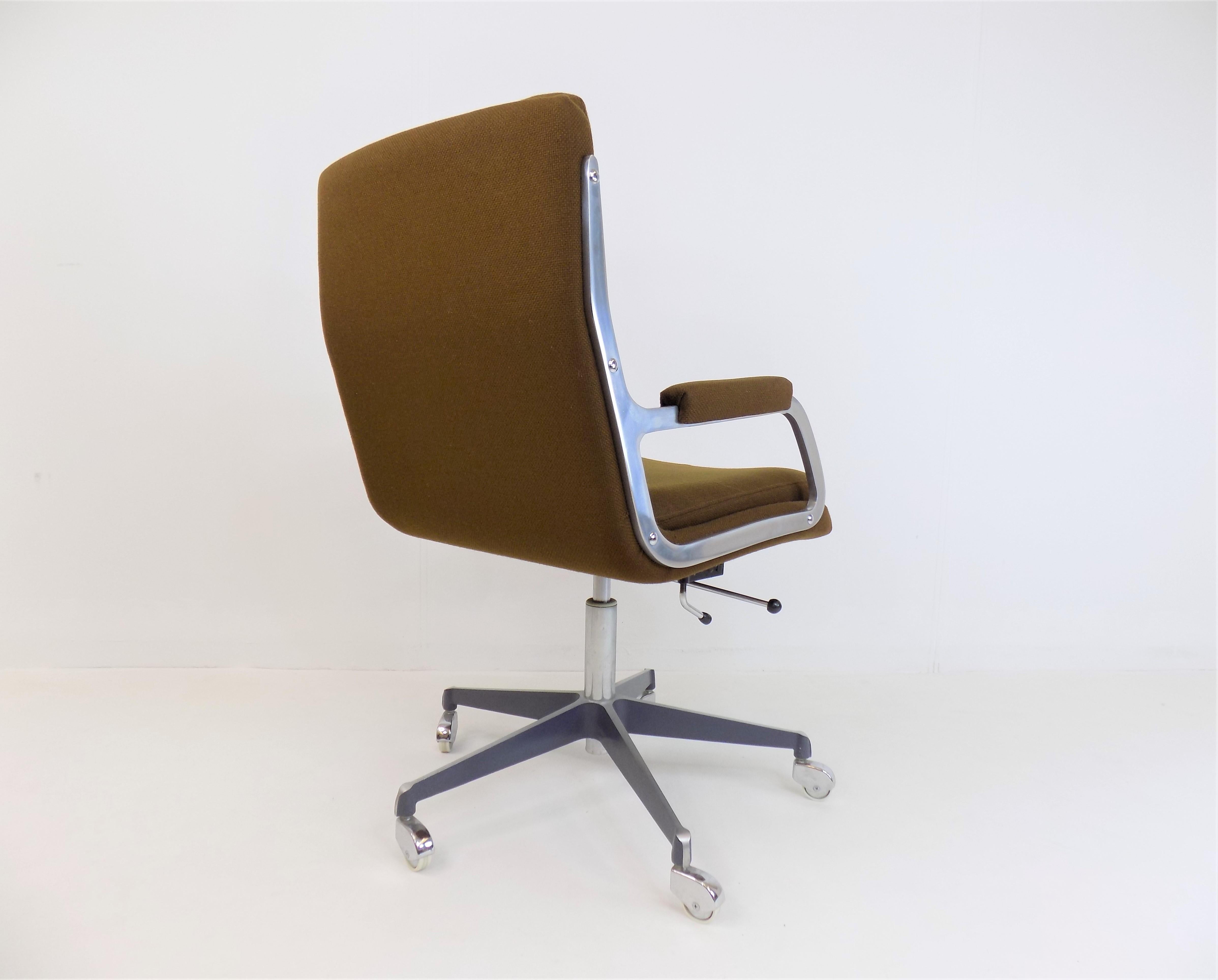 A Ring office chair from the 1960s in exceptional condition. The brown fabric cover shows hardly any signs of wear, the stainless steel rails of the armrests and the armrests themselves are in very good condition. The 5 star base made of polished