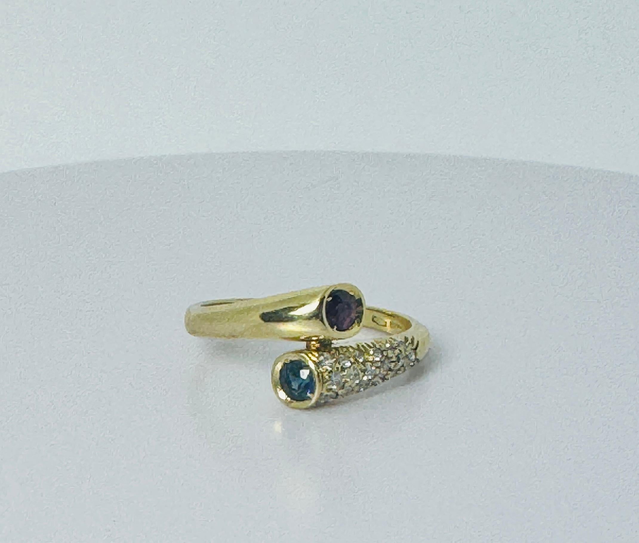 Pre-loved vintage ring with stunning and elegant design.  This jewel is made of 18 carat yellow gold hands holds a ruby and a blue sapphire. On one shoulder this gem has brilliant cut diamonds. This vintage ring with an European origin is for those