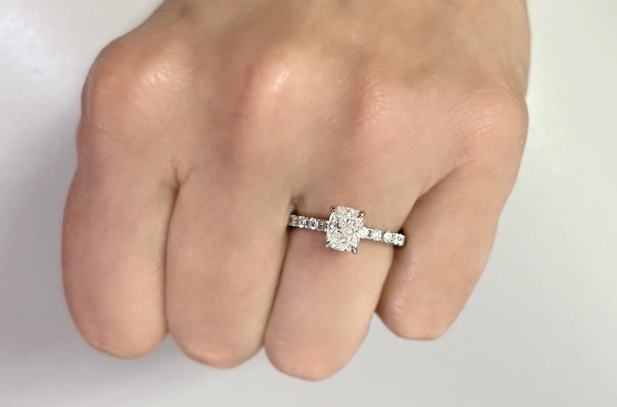 Behold a master piece of love commitment - an engagement ring beyond compare. Crafted in platinum , this symbol of eternal devotion showcases a GIA-certified cushion-cut diamond at its heart, radiating brilliance and fire. Adorning sides, delicate