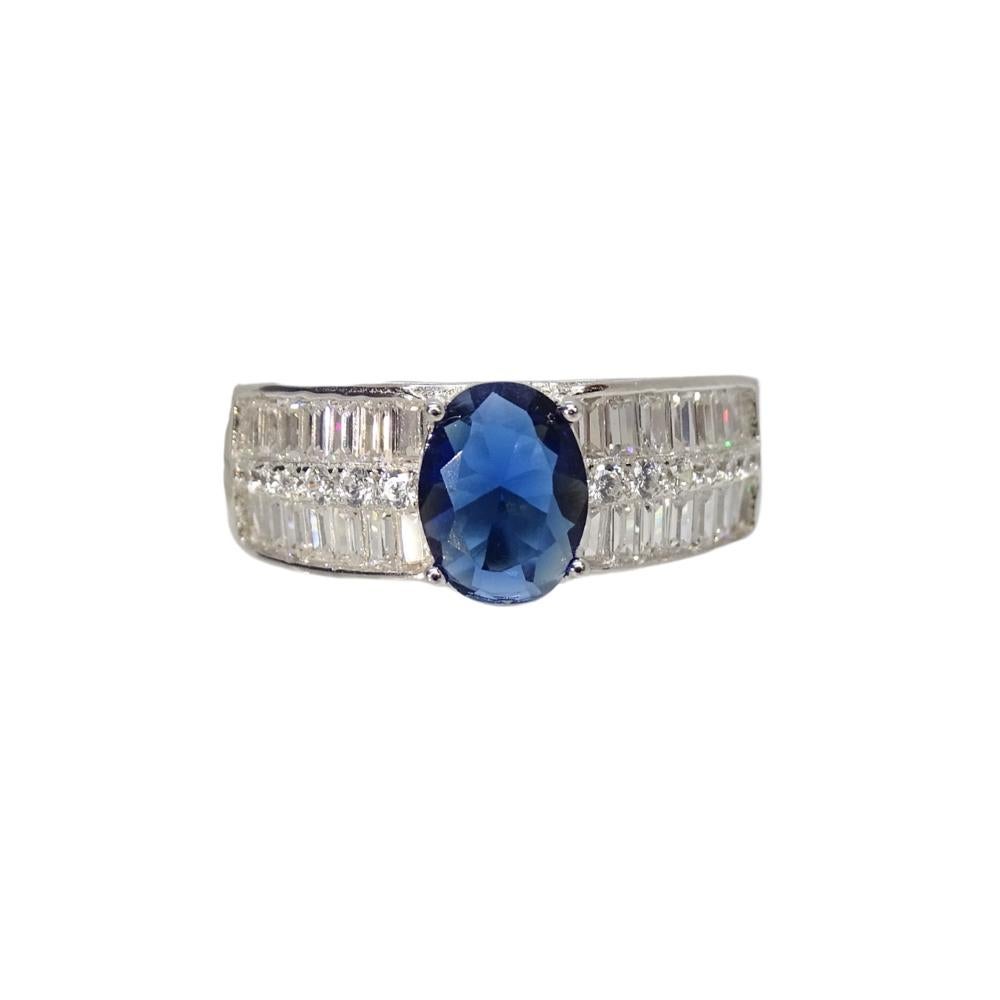 Splendido e unico  anello in argento 925. Le braccia sono divise in tre file di zirconi: quella centrale è a taglio brillante, mentre le file superiori e inferiori sono a taglio baguette. Il pezzo centrale è uno zaffiro di taglio ovale, di un colore