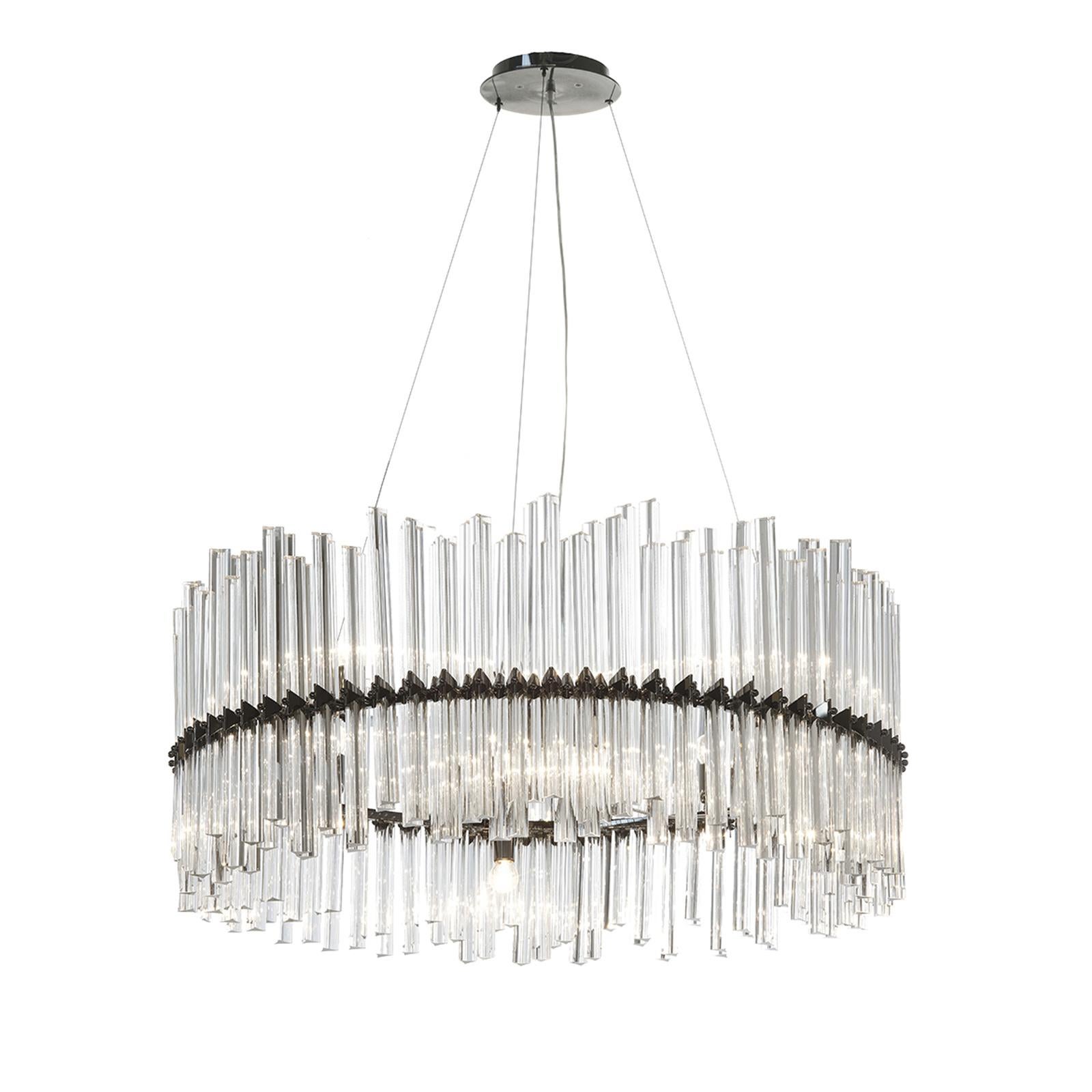 Part of the Ring collection, this unique chandelier is inspired by the bold sophistication of the art deco style, with its rigorous silhouettes and complex textures. The metal structure consists in a top base that supports a circular, ring-shaped