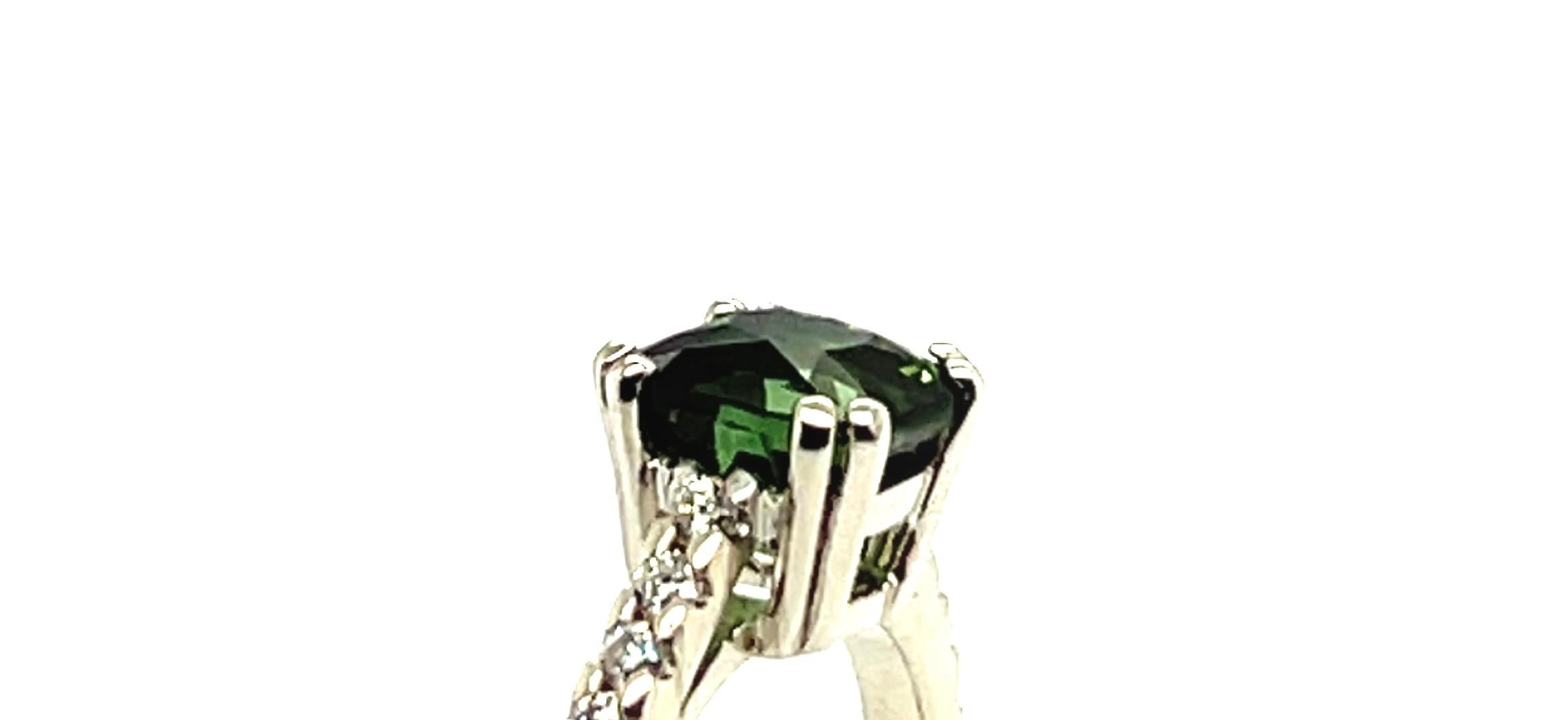 Ring aus Weißgold mit 18 Karat Turmalin im Kissenschliff und Diamanten im Kissenschliff  

Ein eleganter Ring aus 18 Karat Weißgold, besetzt mit einem grünen Turmalin im Kissenschliff, der in einer Vierzackenfassung gefasst ist. Das Band ist mit 14