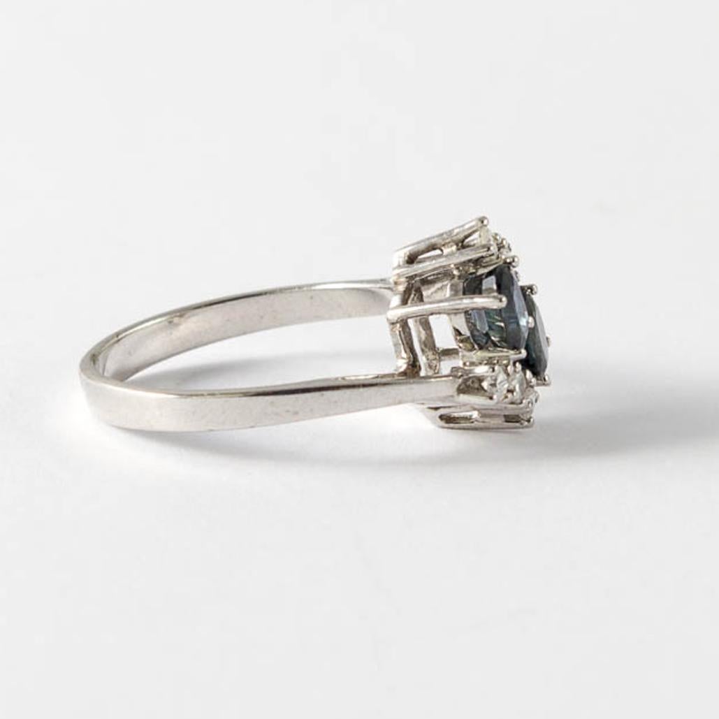 Ring aus Weißgold mit Saphiren und Diamanten

Weißgoldring 585 mit 2 tiefblauen Saphiren im Ovalschliff, je 0,25 ct, umgeben von 6 kleinen Diamanten von je 0,04 ct in enger Fassung

Ringweite: D55, US 7.2

3,2 g

um 1920