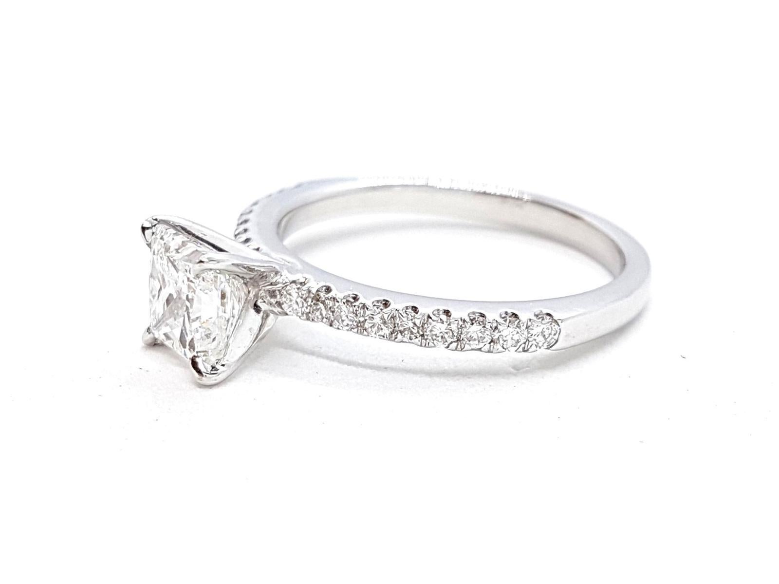 Solitaire in white gold 750 thousandths (18 carats) set with diamonds VS F-size for 1.24 carat total diamond GIA certified center with 1 carat princess cut F-VS2 and supported by 18 round brilliant cut 0.24 ct in total ring size: 53. width on the