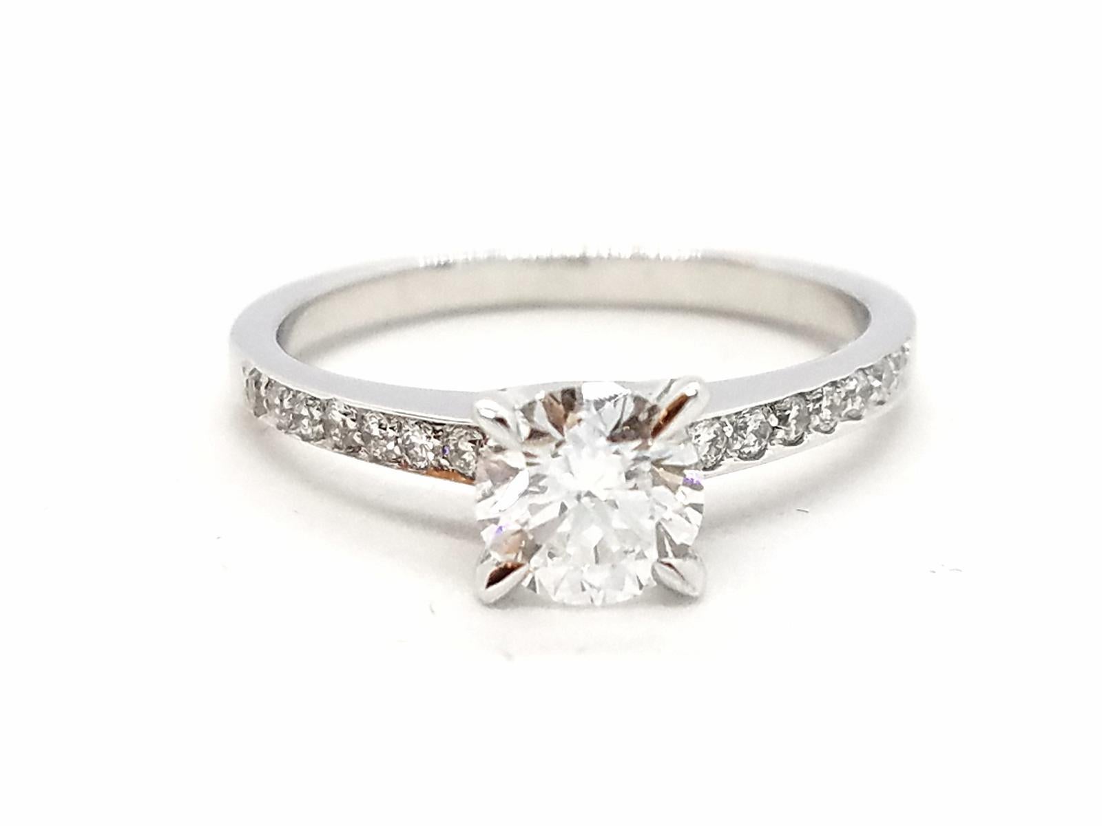 Solitaire in white gold 750 thousandths (18 carats). set with F-VS diamonds for 0.86 ct in total. central brilliant cut diamond F-VS 0.70 ct and supported by 16 brilliant-cut diamonds for a total of 0 16 ct. ring size: 52. width of the ring: 0.16