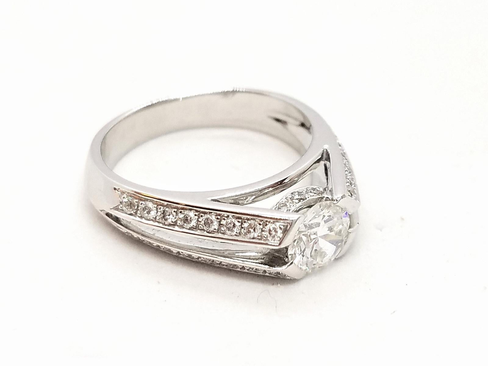 Solitaire in white gold 750 thousandths (18 carats). set with F-VS diamonds for 1.05 carats in total. central brilliant cut diamond F-VS 0.73 ct and 32 diamonds assisted on four lines for a brilliant size total of 0.32 ct. ring size: 54. width of