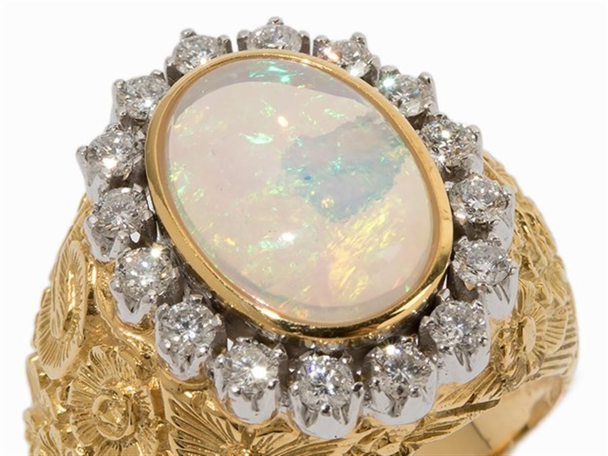 - delineation
- 14 k yellow and white gold, partly with vegetabile relief
- Punched with the fineness
- 1 Crystal Opal cabochon, approx. 3.54 ct and approx. 14.6 x 10.8 mm, with an inclusion (parent rock)
- 16 brilliant-cut diamonds, total approx.