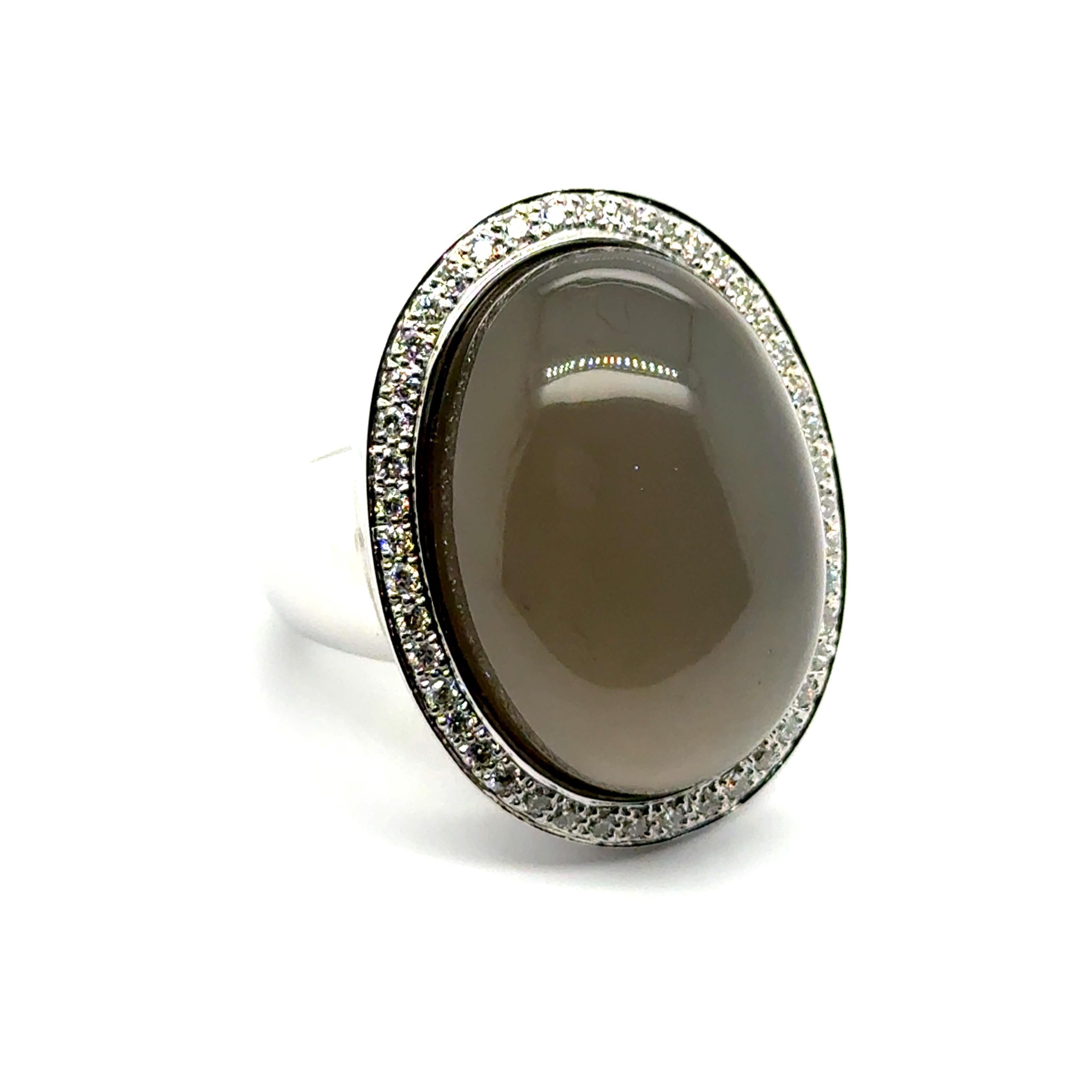 This statement ring is crafted in 18-karat white gold and features a striking 35.00-carat cabochon-cut moonstone, known for its captivating glow that shifts with the light. Surrounding the centerpiece, 44 brilliant-cut diamonds totaling 0.50 carats