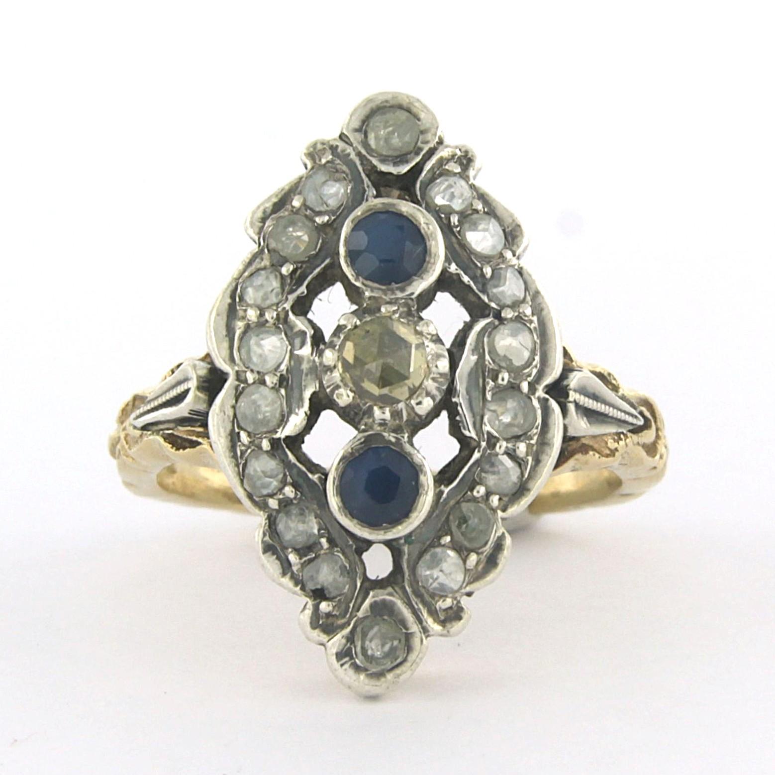 Ring aus 14k Gelbgold mit 835 Silber, besetzt mit einem Saphir und einem Diamanten im Rosenschliff 0,18 ct - G/H - SI - Ringgröße US 6.5 - EU 17 (53)

Ausführliche Beschreibung:

Die Oberseite des Rings ist 2,2 cm breit und 7,0 mm hoch.

Ringgröße