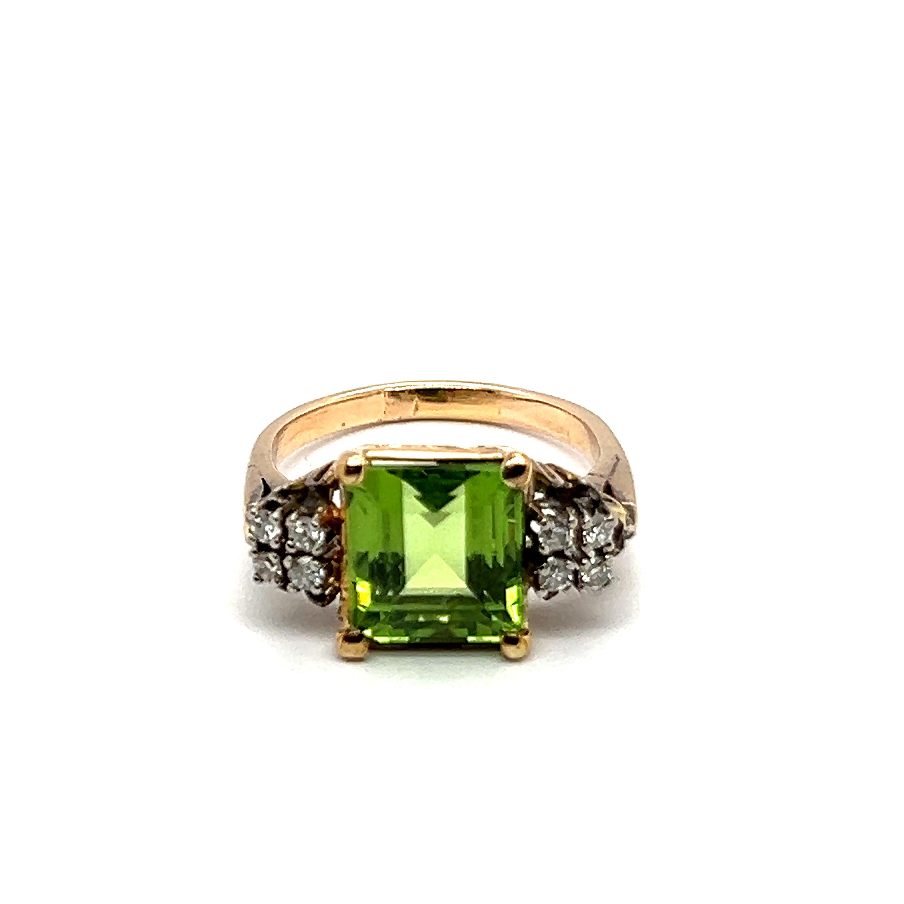 This exquisite ring, fashioned from 14-karat red and white gold, evokes the beauty of nature. 

At its center lies a stunning 3.50-carat square-cut peridot, known for its vibrant green hue and believed to bring harmony. Surrounding the peridot are