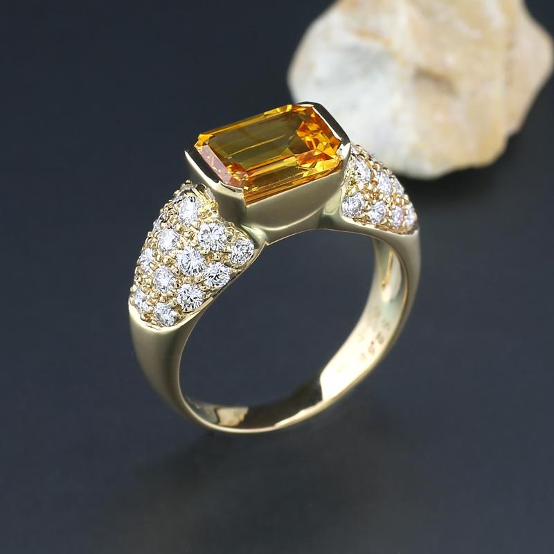 valuable cocktail-ring with a sapphire approximately 2.58 carats,  octagonal cut, a bright, eye-clean orange color. 32 natural brilliant cut diamonds totaling approximately 0.92 carats, color: Top Wesselton, clarity: VS. Ring crafted in 18 Karat