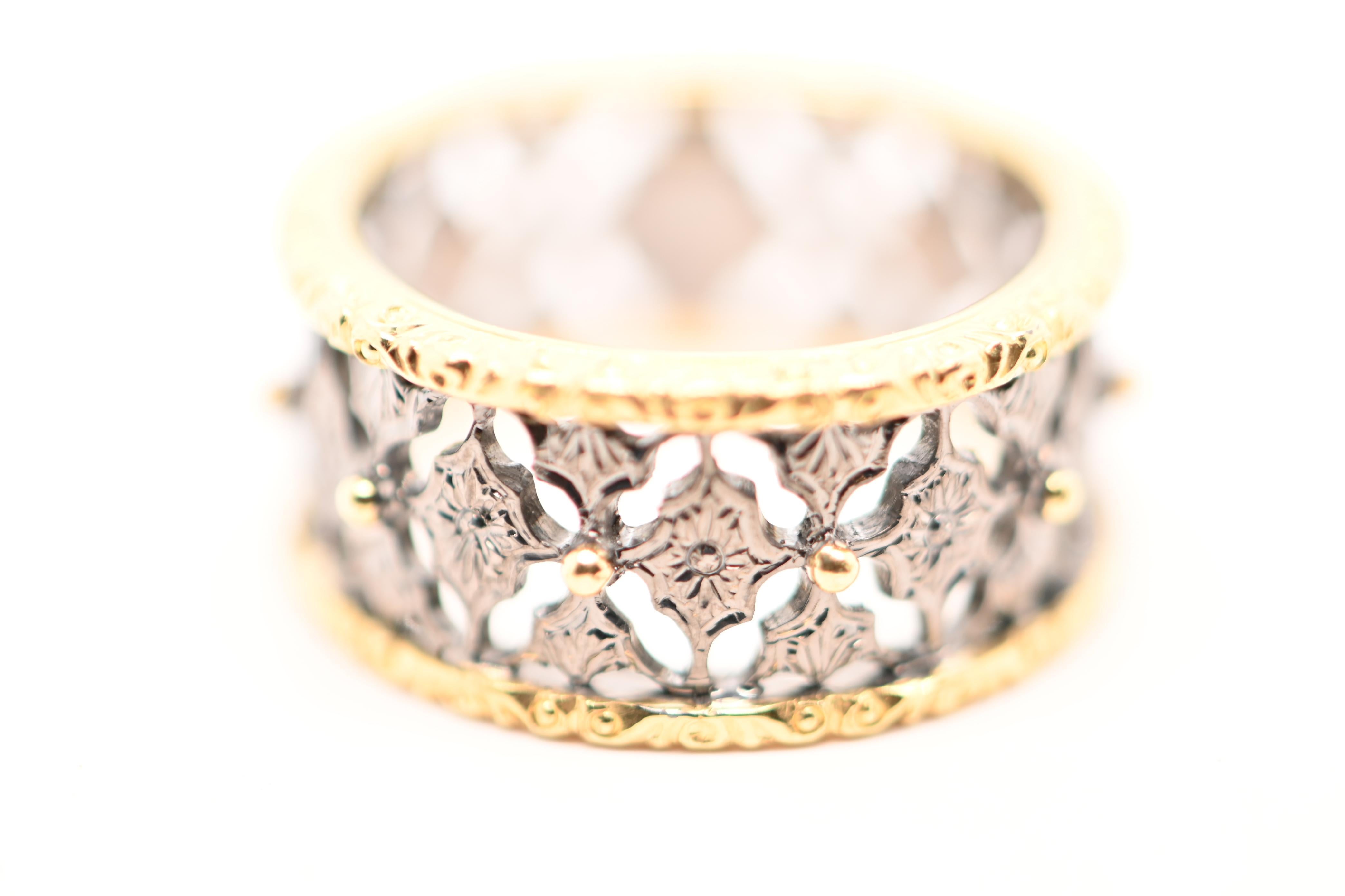 This unique two-tone ring in yellow and black gold is a piece of jewelry of great finesse and remarkable refinement. Designed in a band style, it features openwork details inspired by lace patterns, giving the ring a timeless elegance. The yellow