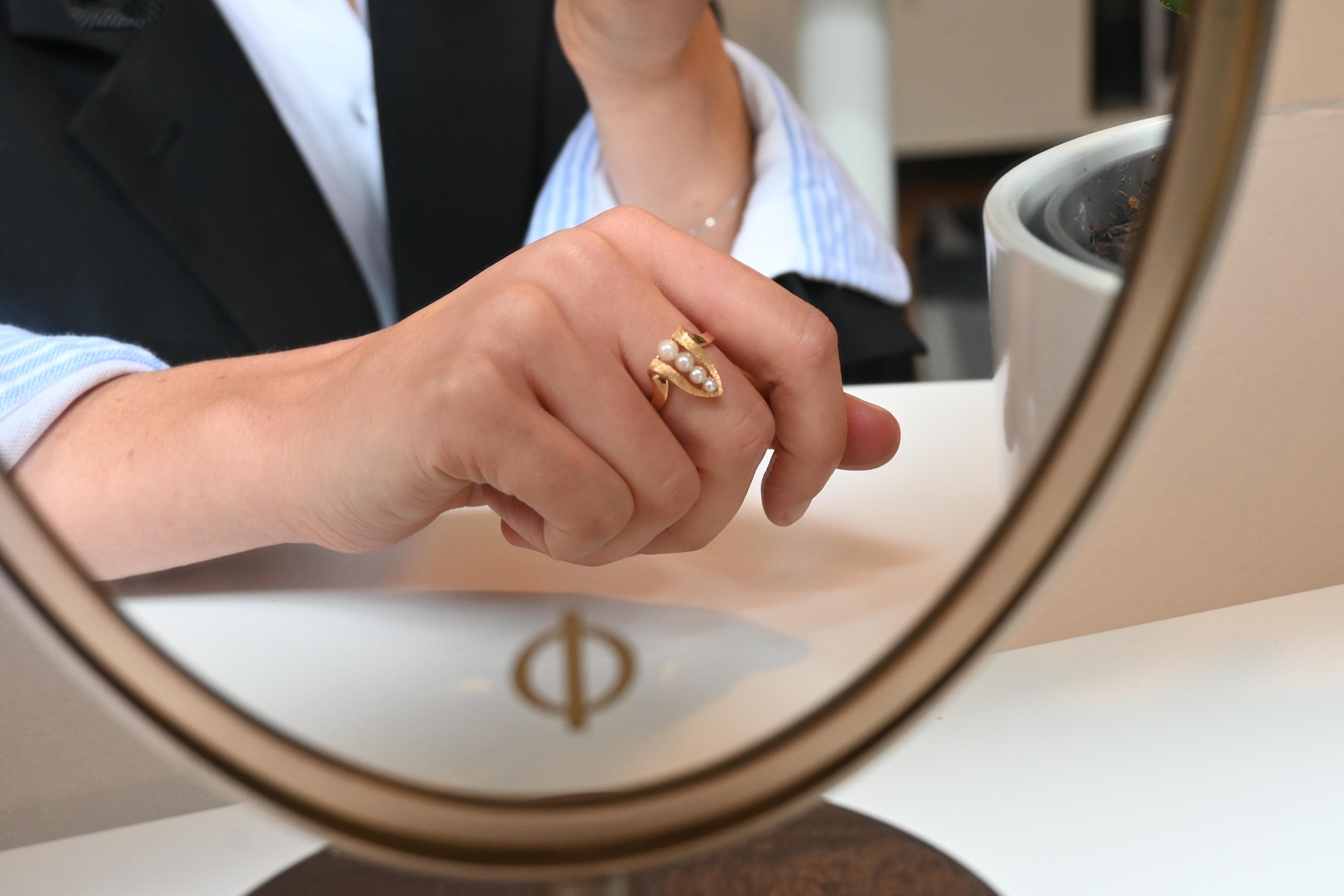 Gold ring with cultured pearls Ring in 18k yellow gold, with a leaf-shaped reverse in the center. The contour is finely engraved, highlighting the center of the leaf. Four cultured pearls, from the smallest to the largest, are set in the center of