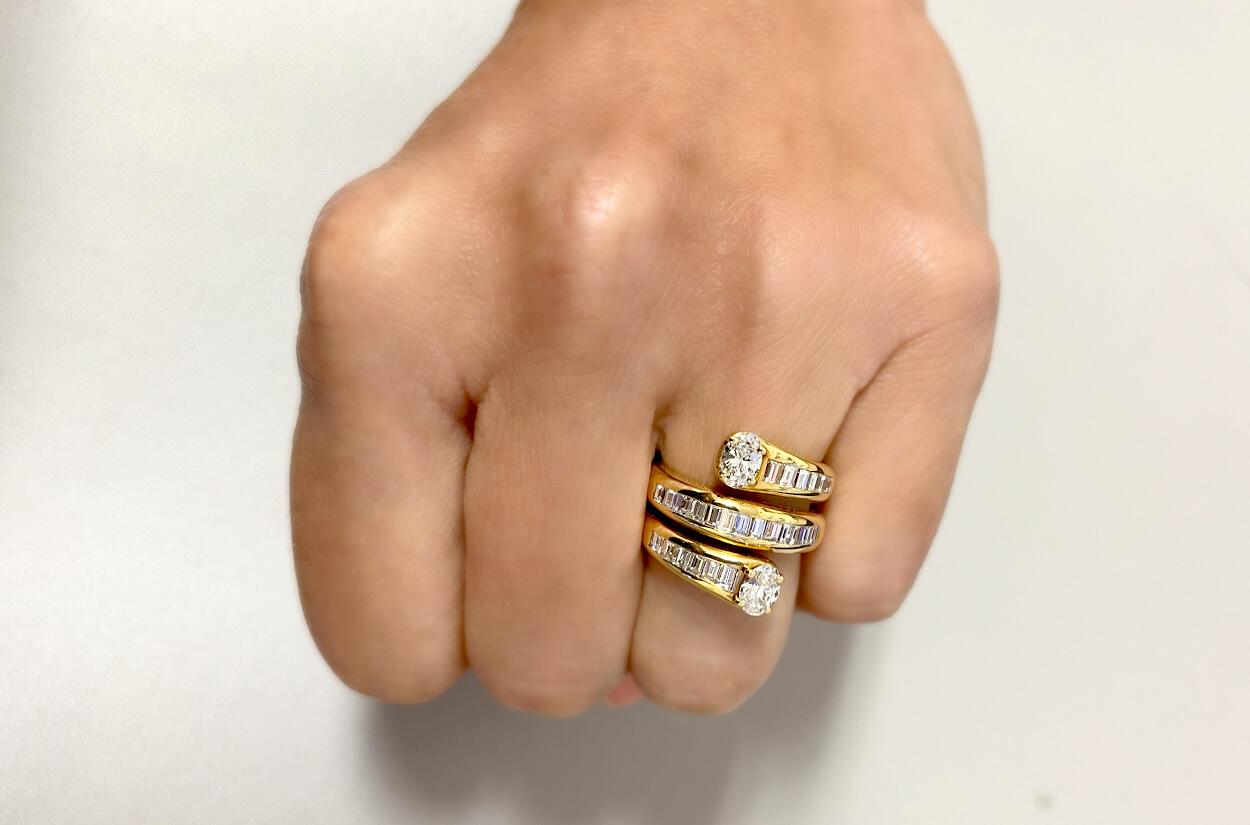 An enchanting 18kt yellow gold ring takes the captivating form of a sinuous snake. This unique design is adorned with shimmering allure of baguette-cut diamonds, which gracefully wind their way along the serpent's bod. On the either of the sides two