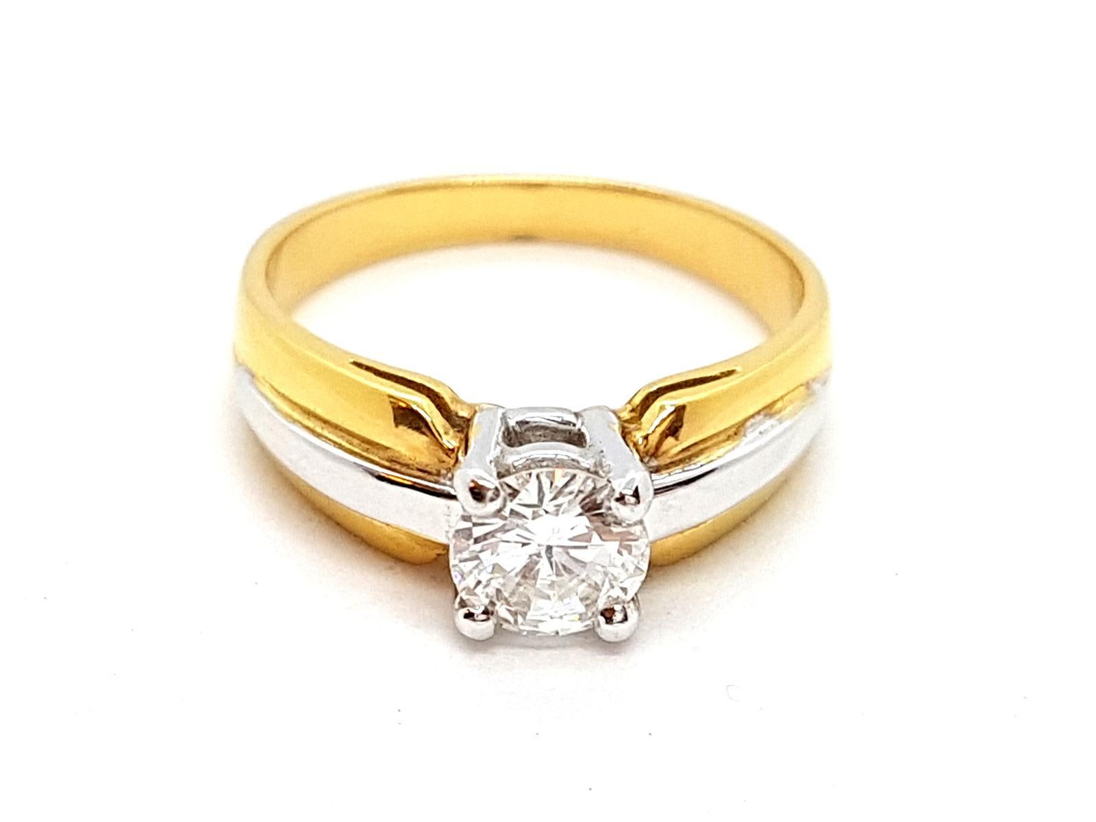 Solitaire in gold 750 thousandths (18 carats) two-tone. yellow gold and set on white gold a diamond. brilliant size  of about 0.80 ct. finger circumference: 56. width on top: 0.6 cm. total weight: 5.56 g. new condition. eagle head hallmark

