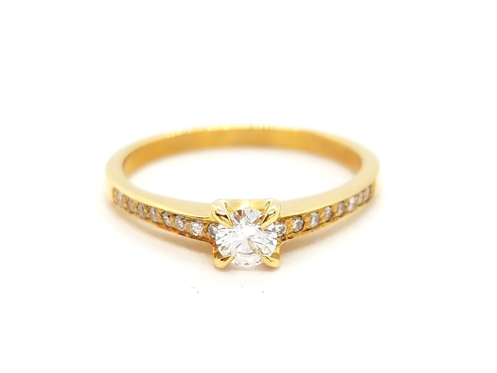 Solitaire 750 thousandths yellow gold (18 carats). set with F-VS diamonds for 0.36 ct in total. central brilliant cut diamond F-VS 0.20 ct and supported by 16 brilliant-cut diamonds for a total of 0 16 ct. ring size: 53. width of the ring: 0.16 cm.