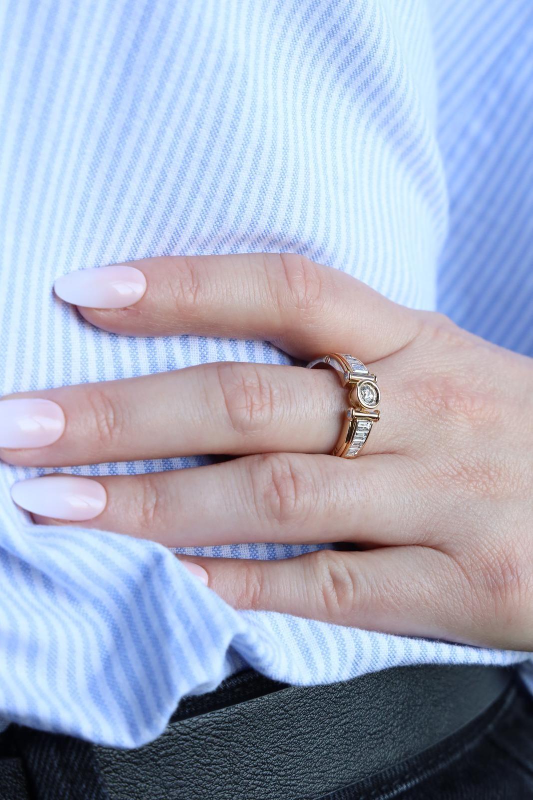 Ring aus Gelbgold 750 Tausendstel (18 Karat). besetzt mit einem Diamanten im Brillantschliff. ca. 0,21 ct. und 8 Diamanten im Baguetteschliff. 4 von je etwa 0,14 ct. und 4 von je etwa 0,10 ct. Gesamtgewicht der Diamanten: 1.17 ct. Fingergröße: 59.