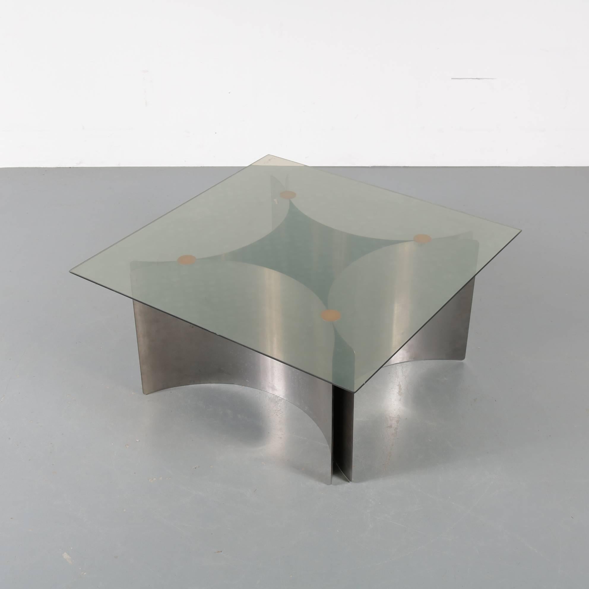 A wonderful coffee table, attributed to Ringo Starr and Robin Cruikshank for ROR in the United Kingdom, circa 1970.

It has a bent, chrome plated metal frame made of four plates that create a diamond shaped base. The clear glass square top adds