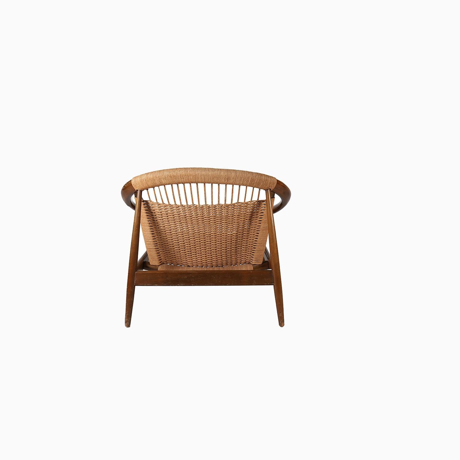 una poltrona vintage originale realizzata in legno di faggio colorato e corda di carta intrecciata.  struttura lounge firmata a forma di cerchio o anello con seduta e schienale in corda intrecciata che si uniscono in un angolo ripido in stile metà