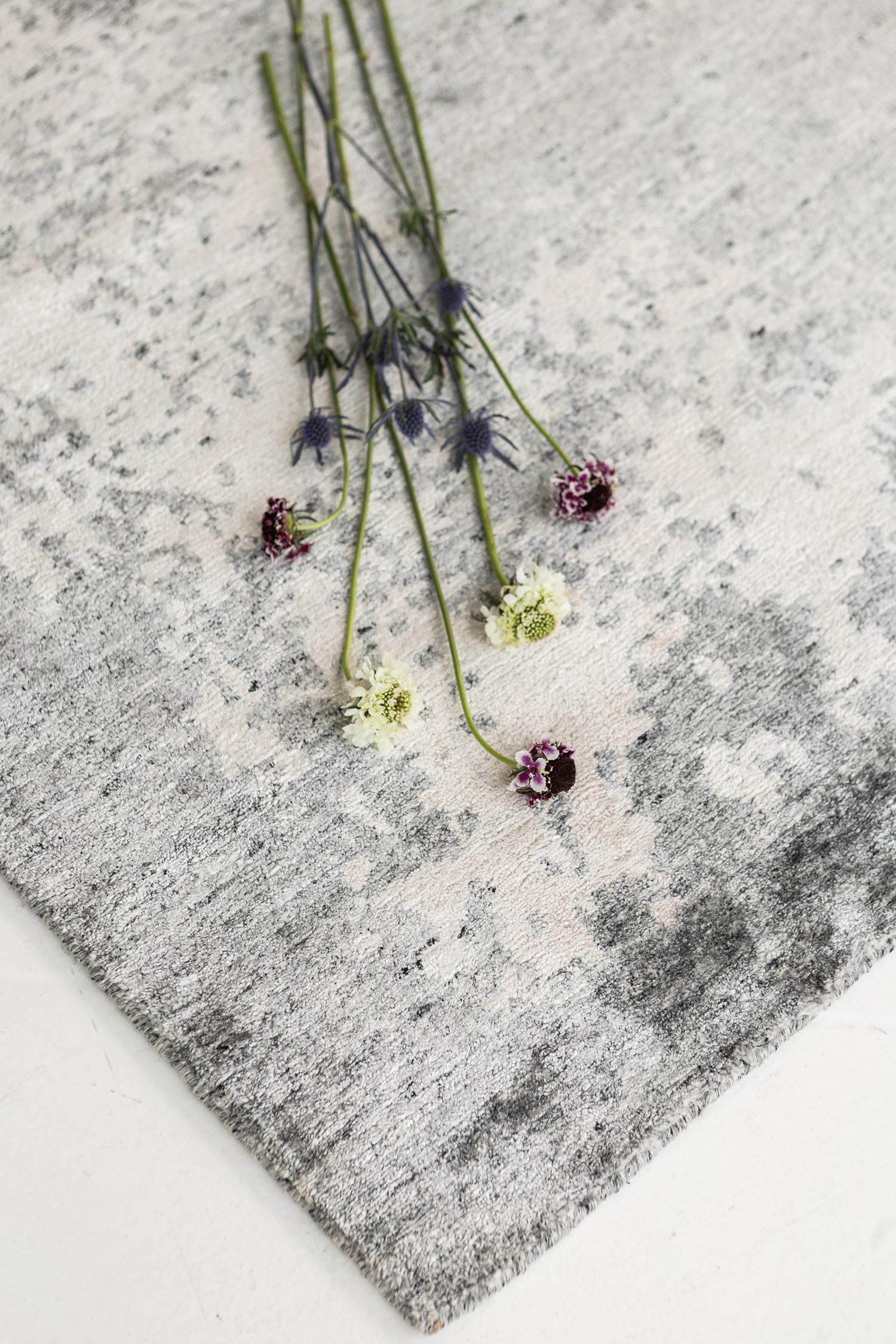 'Rinka’ is a modern transitional rug that features natural gray and cream color palette. Rich waves of abrash and patina give dimension and visual interest to the understated yet impactful design in which every element of this piece radiates