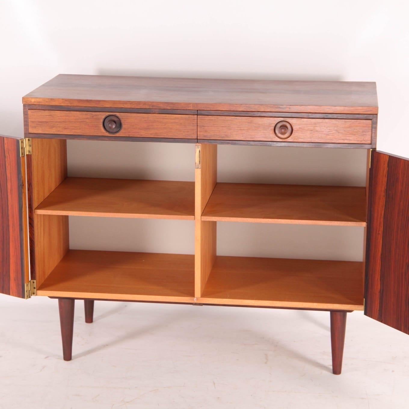 Bellissima credenza in palissandro Rio con 2 cassetti e 2 ante. 2 ripiani e una chiave.
Ottima qualità e condizione. Raro 