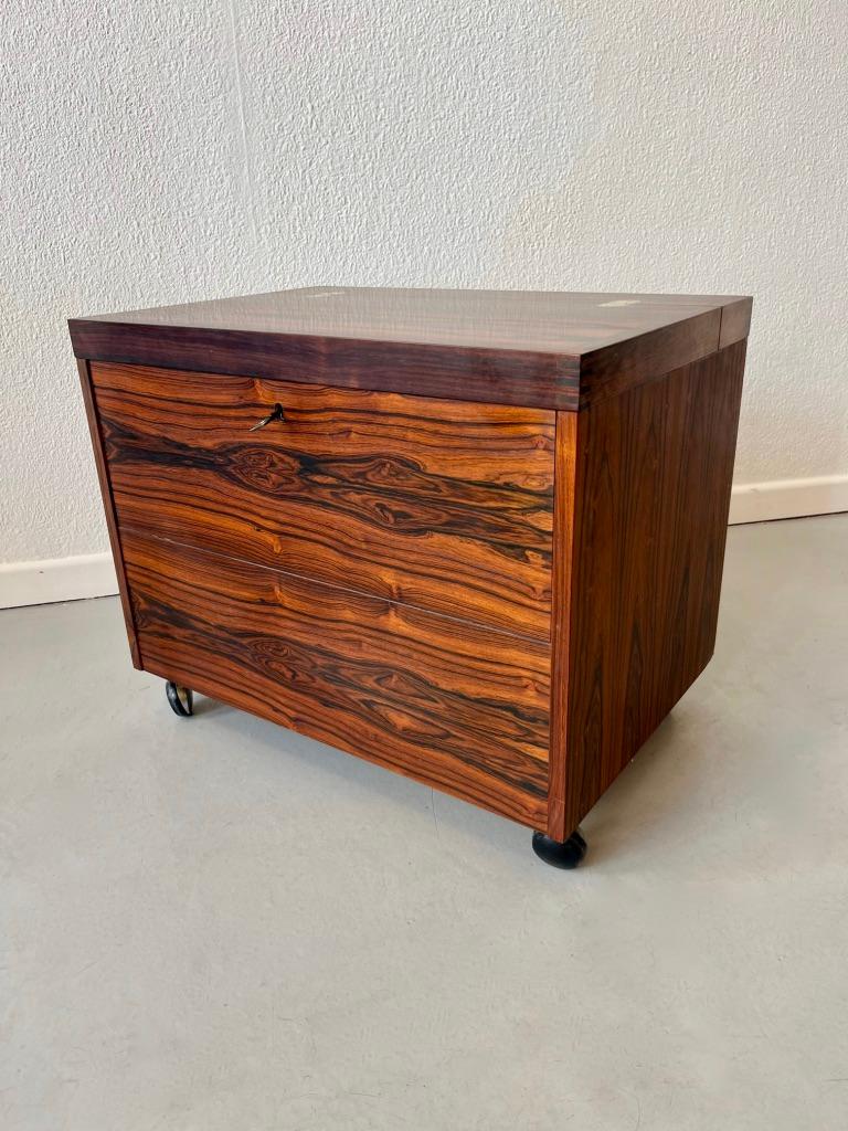 Rio Rosewood cube bar by Rolf Hesland produced by Bruskbo, Norway ca. 1960
Rio rosewood frame with brass fittings, mounted on wheels.
Lid-top and fold-down front, interior with bottle storage and shelf. Side mounted with drawer.
Very good condition.