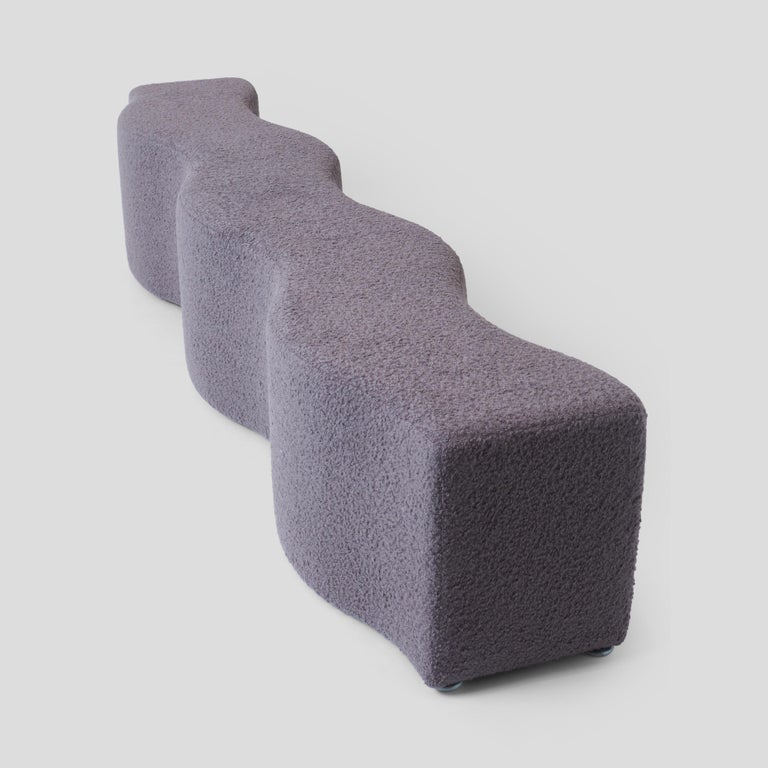 A sculptural ripple bench by Laurinda Spear for Steelcase. Newly reupholsterd in a luxurious lavender grey bouclé by Sandra Jordan Prima Alpaca. The bench sits on height adjustable glides.