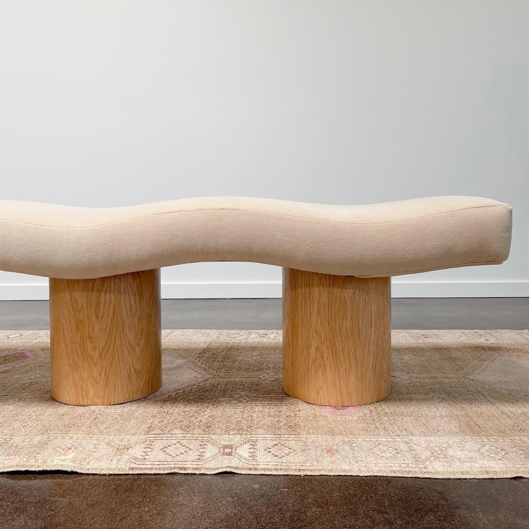 A one of a kind Postmodern ripple bench with new oak drum legs. The bench has been reupholstered by the Selby House in a Holland & Sherry wool velvet. 