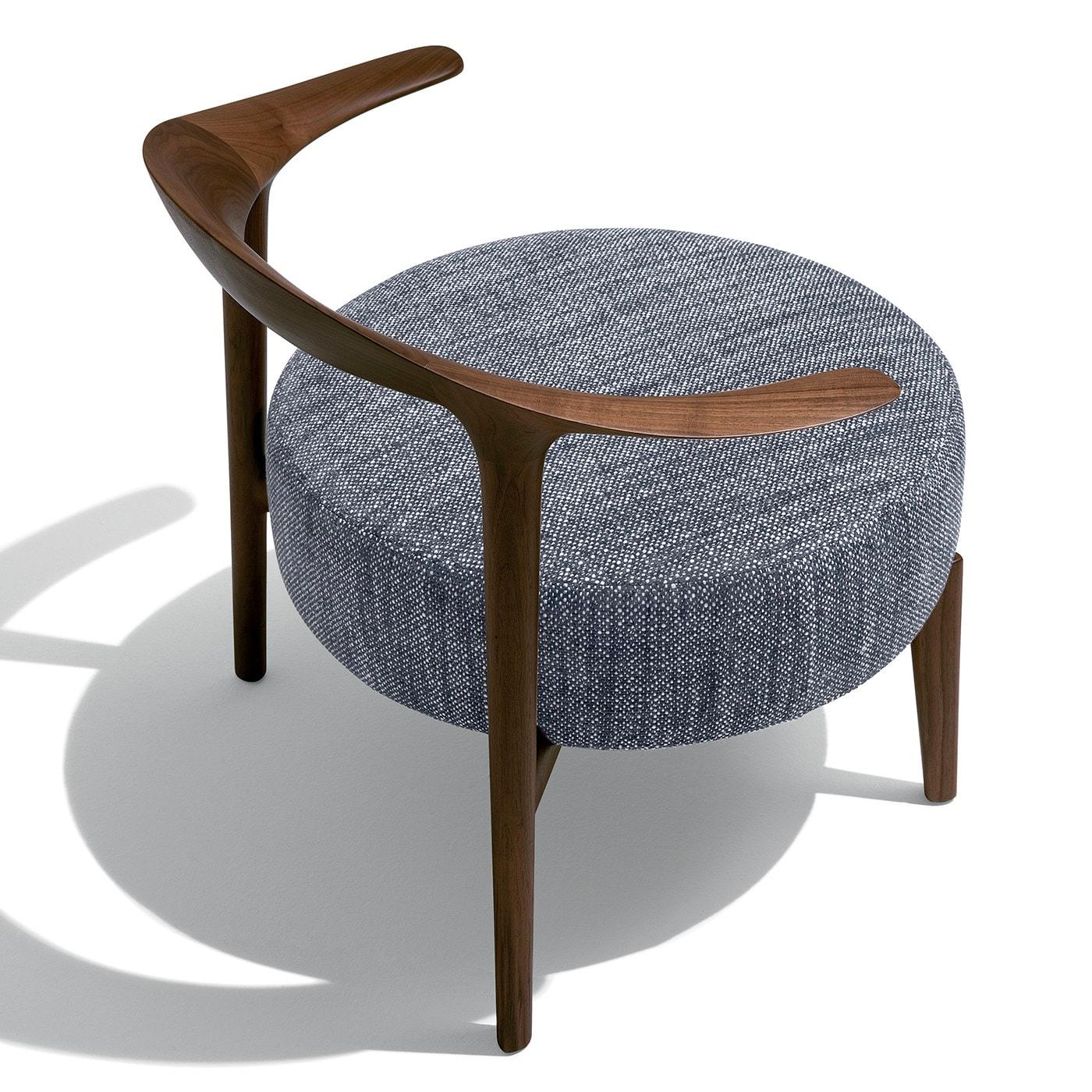 Con un diseño sofisticado de limpio valor geométrico, este elegante sillón de salón impregnará un interior contemporáneo del máximo refinamiento. Proporciona una comodidad excepcional y está hecho a mano con madera maciza de nogal. El asiento