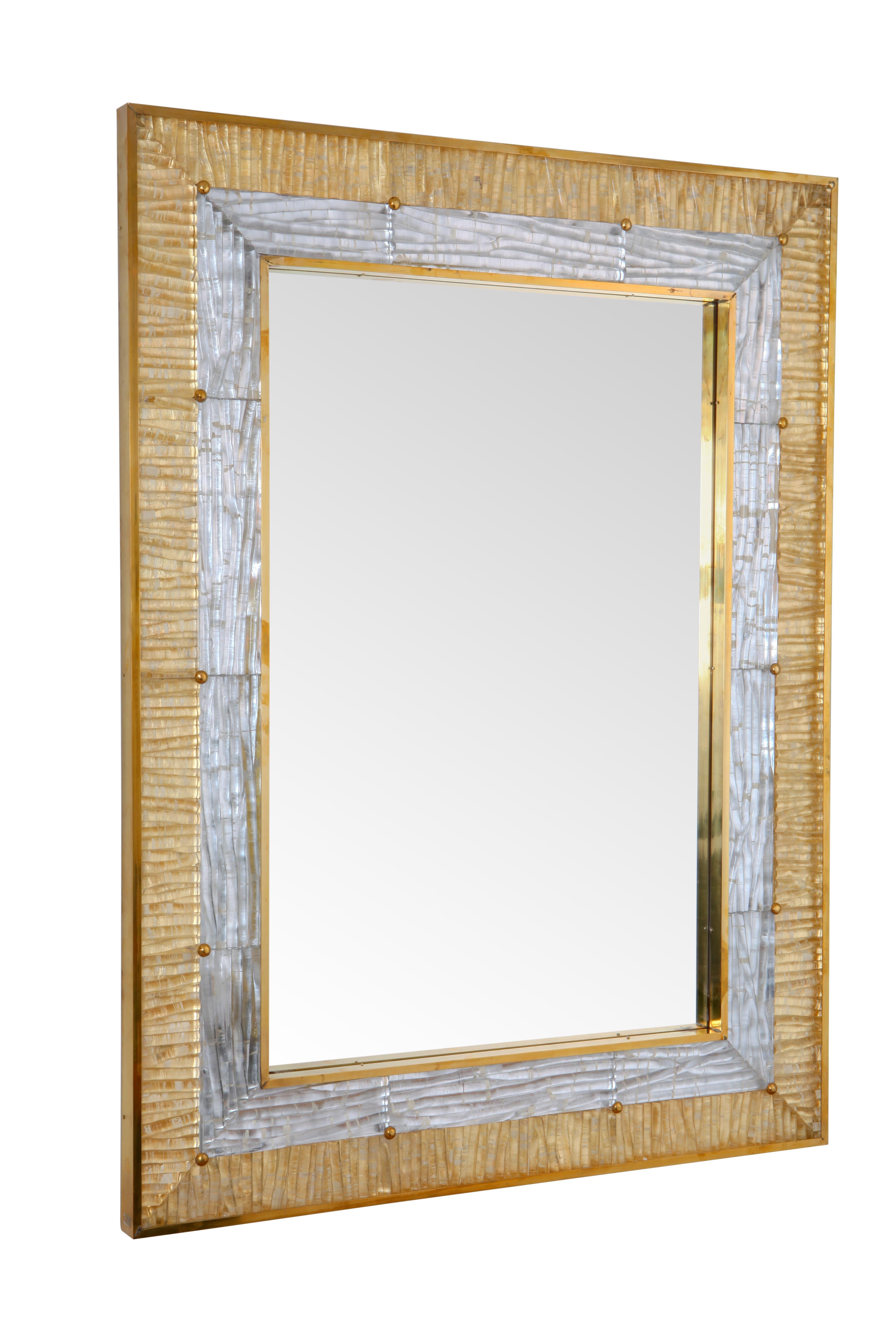 This mirror houses Murano glass tiles set in an un-lacquered brass frame around a plain mirror sheet. 

The ribbed glass is secured with brass tacks into the frame.

This mirror is also customisable should you wish to have a different size. 

The
