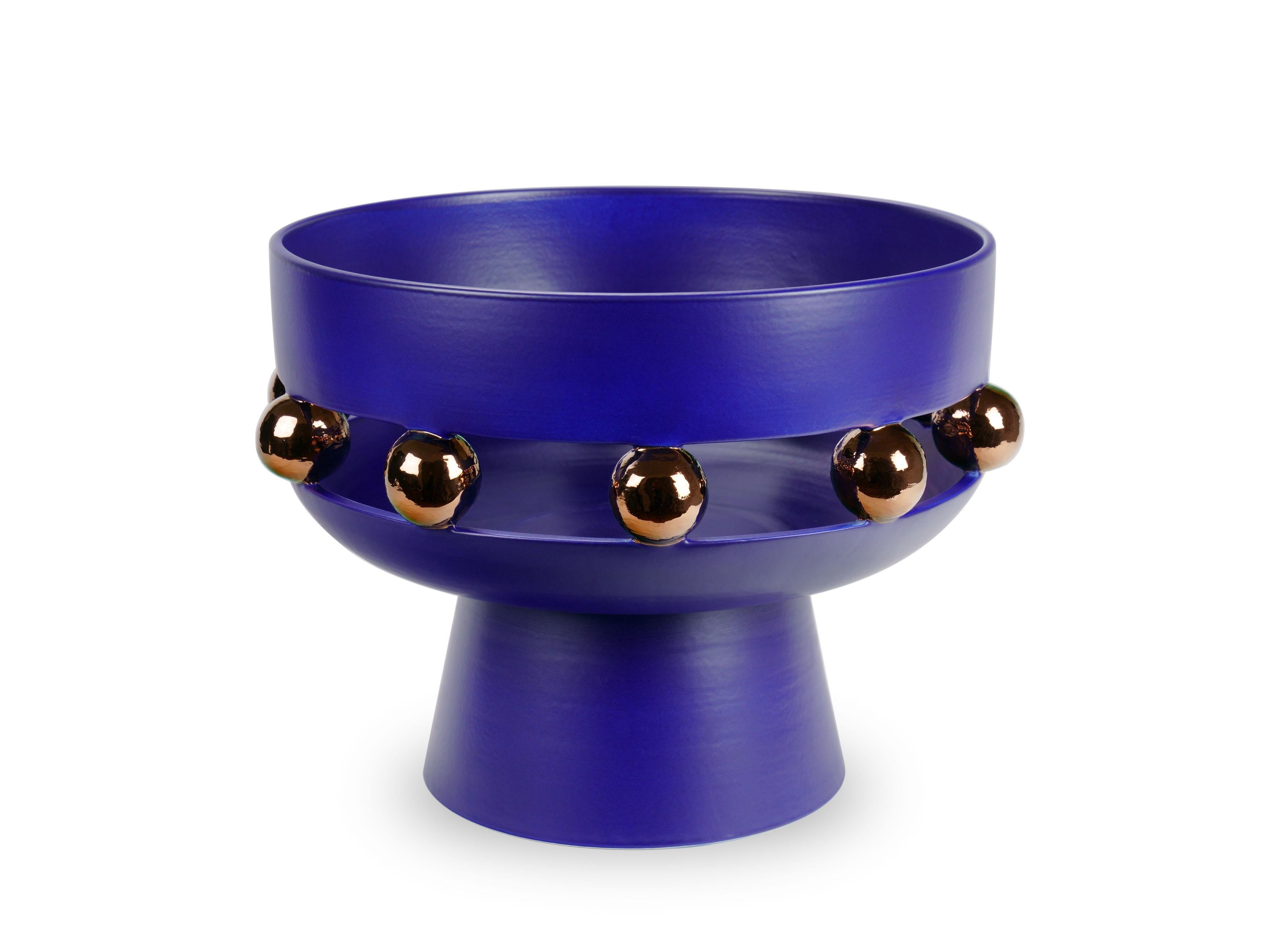 Large ultramarine blue riser bowl or centerpiece vase with a matte finishing, alternating with reflective surfaces embellished with copper metallic luster. This technique sees ceramics to undergo three cooking phases: the last one, called third