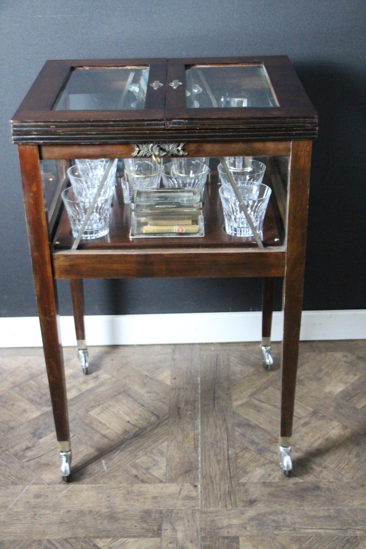 This English cocktail cabinet is particularly unusual and elegant.
Made of magnificent brown color walnut, from 1950's , it has all glass sides and glass top section.Its top section pops up to reveal a full set of 6 large Baccarat glasses, 2 small