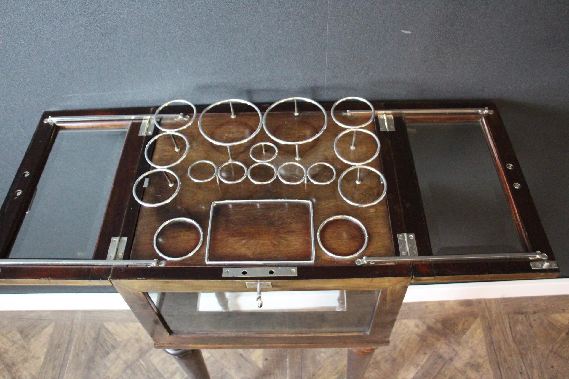 
 This English cocktail cabinet is particularly unusual and elegant.
Made of magnificent brown color walnut, from 1950's , it has all glass sides and glass top section.Its top section pops up to reveal a full set of 6 large Baccarat glasses, 6 small