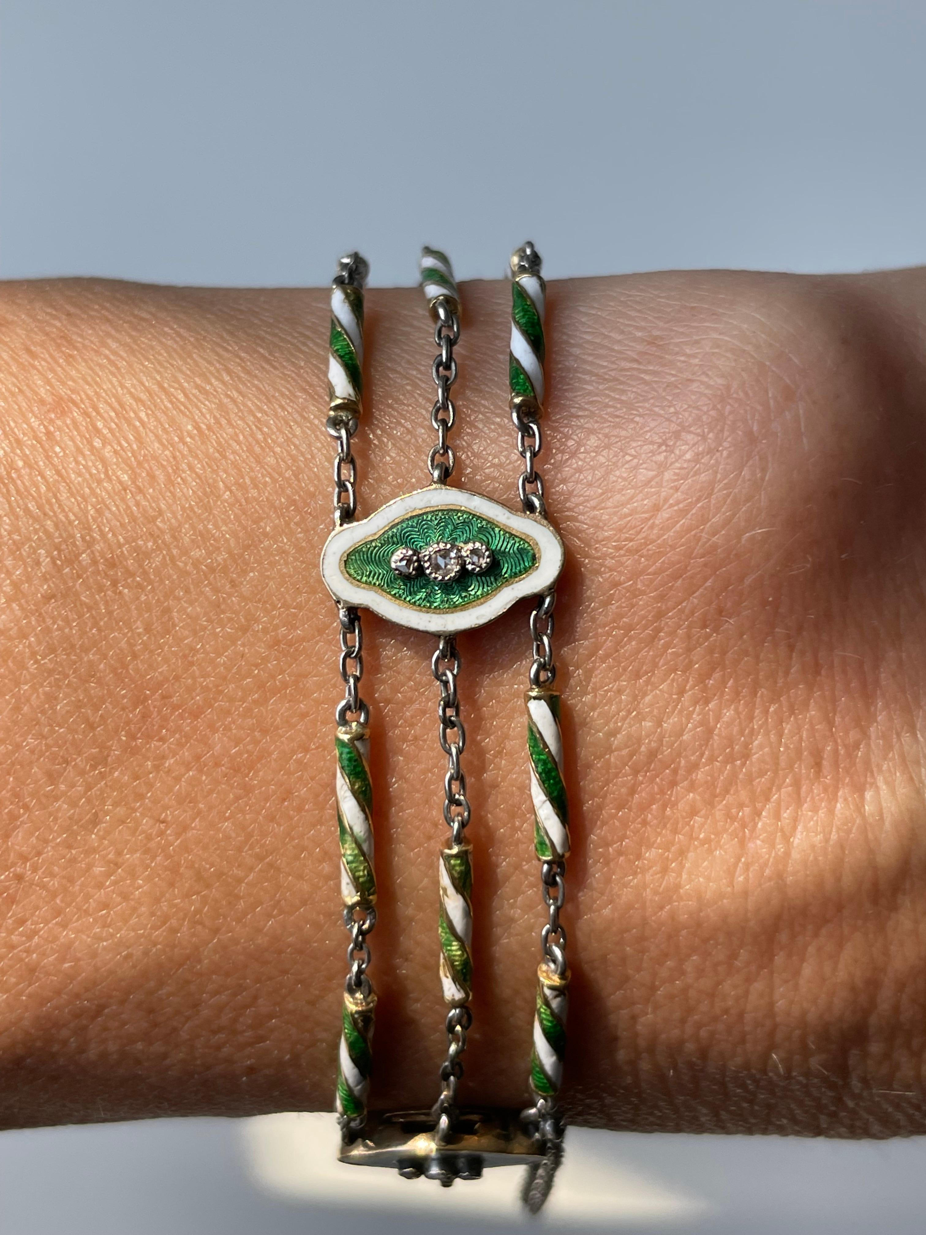 Dating from the Belle Époque era, this precious bracelet by Risler & Carre is comprised of five quatrefoil plaques, decorated with a trio of twinkling rose-cut diamonds mounted on a glossy emerald green guilloche, contained within a white enamel