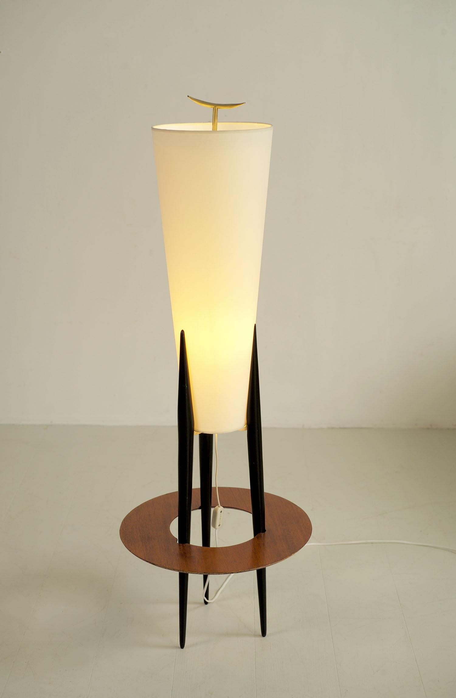 Lámpara de pie trípode de estilo japonés fabricada por la Maison Rispal con el número 14496, Francia 1960. La base de madera ennegrecida está rodeada por una repisa circular perfilada, chapada en caoba. La pantalla troncocónica se inserta entre las