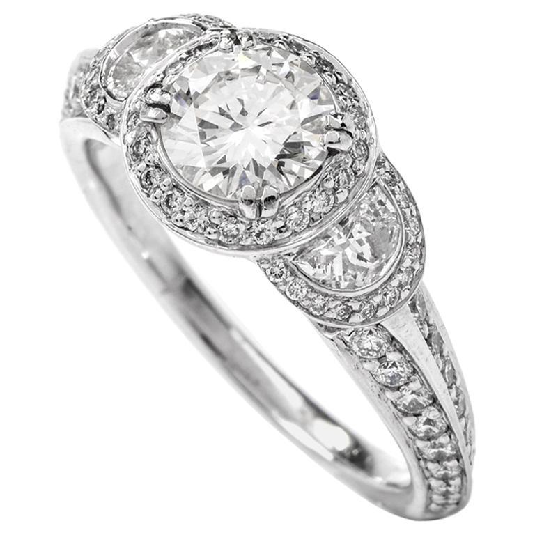 This exquisite designer ‘ Ritani ‘diamond engagement ring is crafted in solid platinum. At the center and supported by a delightful openwork gallery, we find a sparkling brilliant round-cut diamond of approx. 0.95ct, H-I color, VS clarity, and two