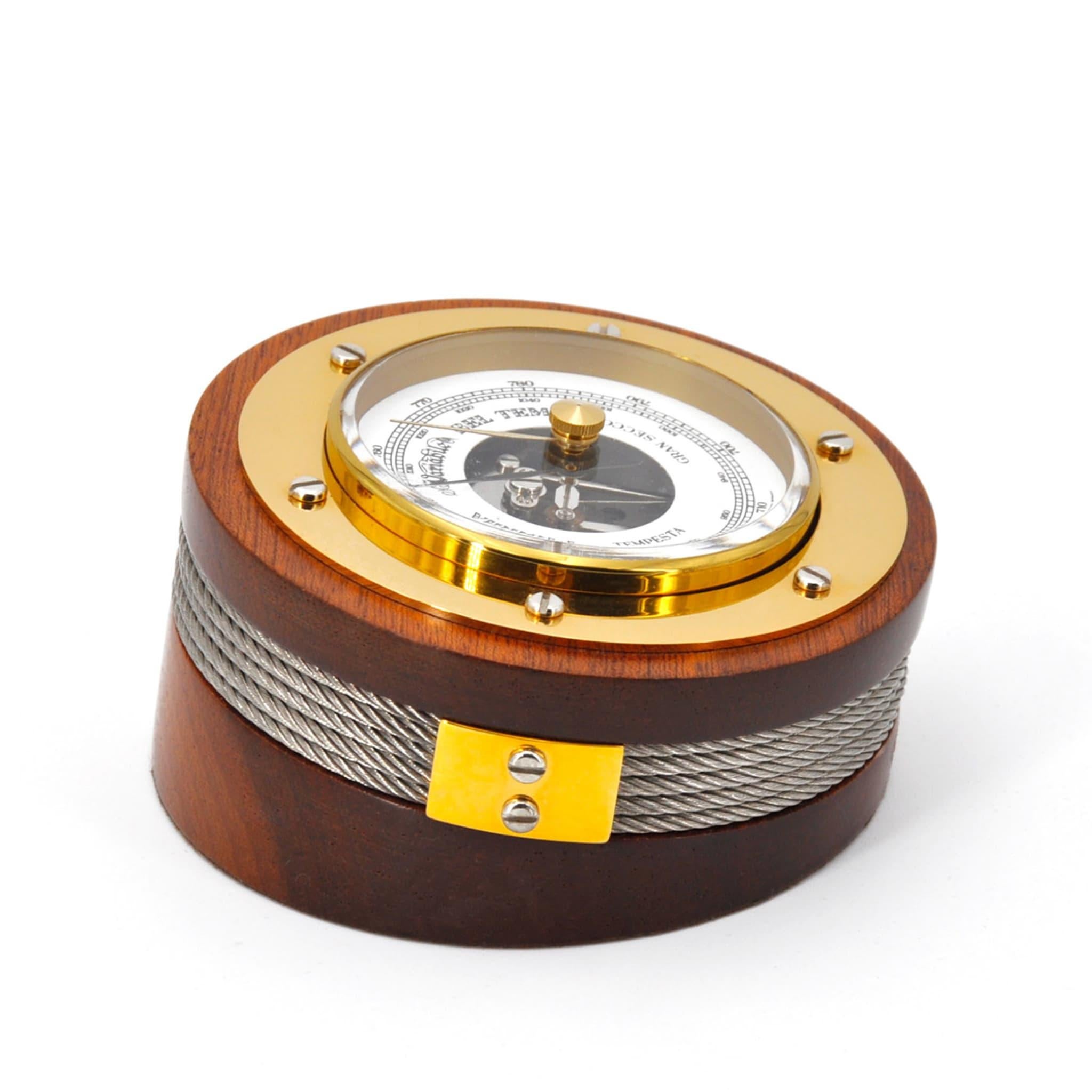 Part of the Ritmi Marini Collection designed by artist Nino Basso, this barometer is a timeless classic of refined Nautical-inspired style. Handcrafted of mahogany wood enriched with 24K gold plated-brass details and a stainless steel cord, it comes