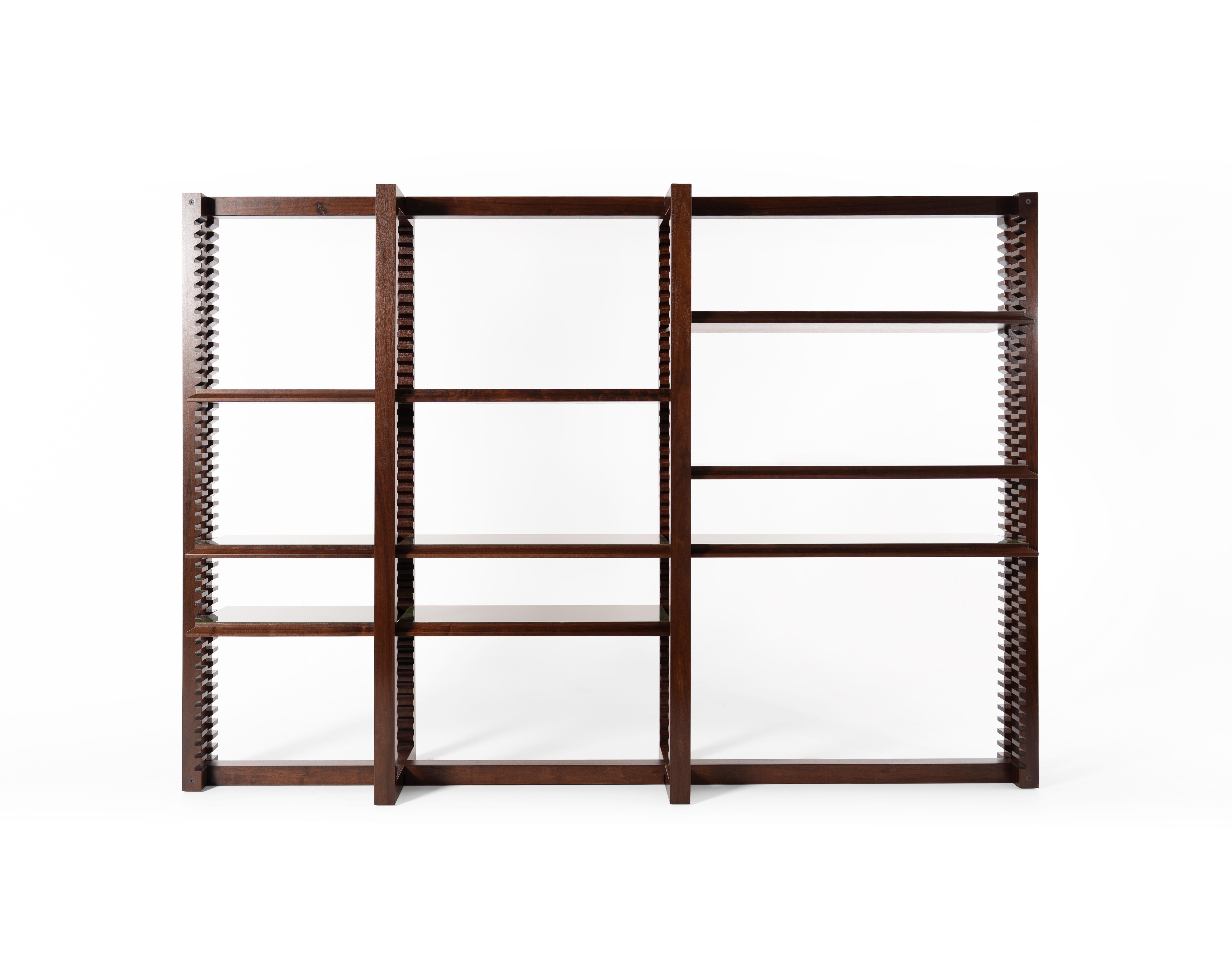 Ritmica è una libreria bifacciale, portante e modulare, progettata per integrarsi con eleganza e funzionalità negli spazi abitativi e negli ambienti professionali. Il meccanismo a cremagliera dei montanti è realizzato in noce massiccio con un'anima