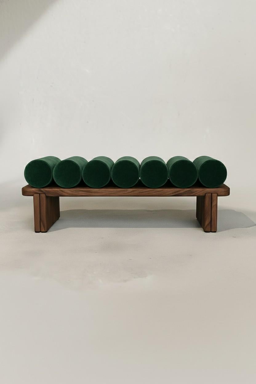 La panchina Ritmo Platform Bench esplora la ripetizione ritmica attraverso la sua sequenza di cuscini cilindrici a rullo, ognuno dei quali è rivestito in velluto felpato per creare una superficie di seduta scultorea e simile a una trapunta. La base