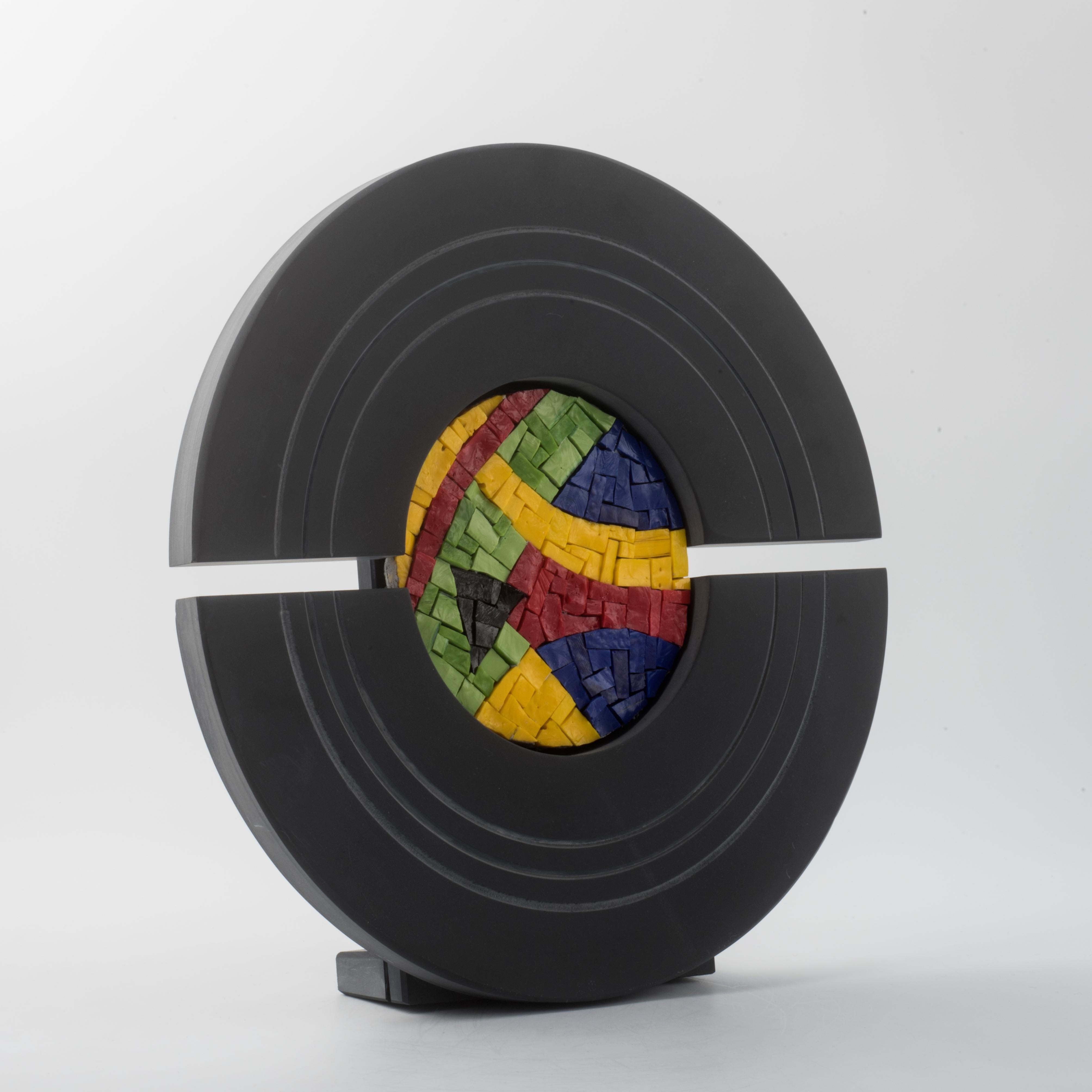 Elegante  escultura contemporánea del artista Nino Basso, RITMO COLORATO combina la solidez de la pizarra con la expresividad del mosaico veneciano hecho a mano.
La composición está realizada sobre una forma circular en pizarra pulida, dividida en