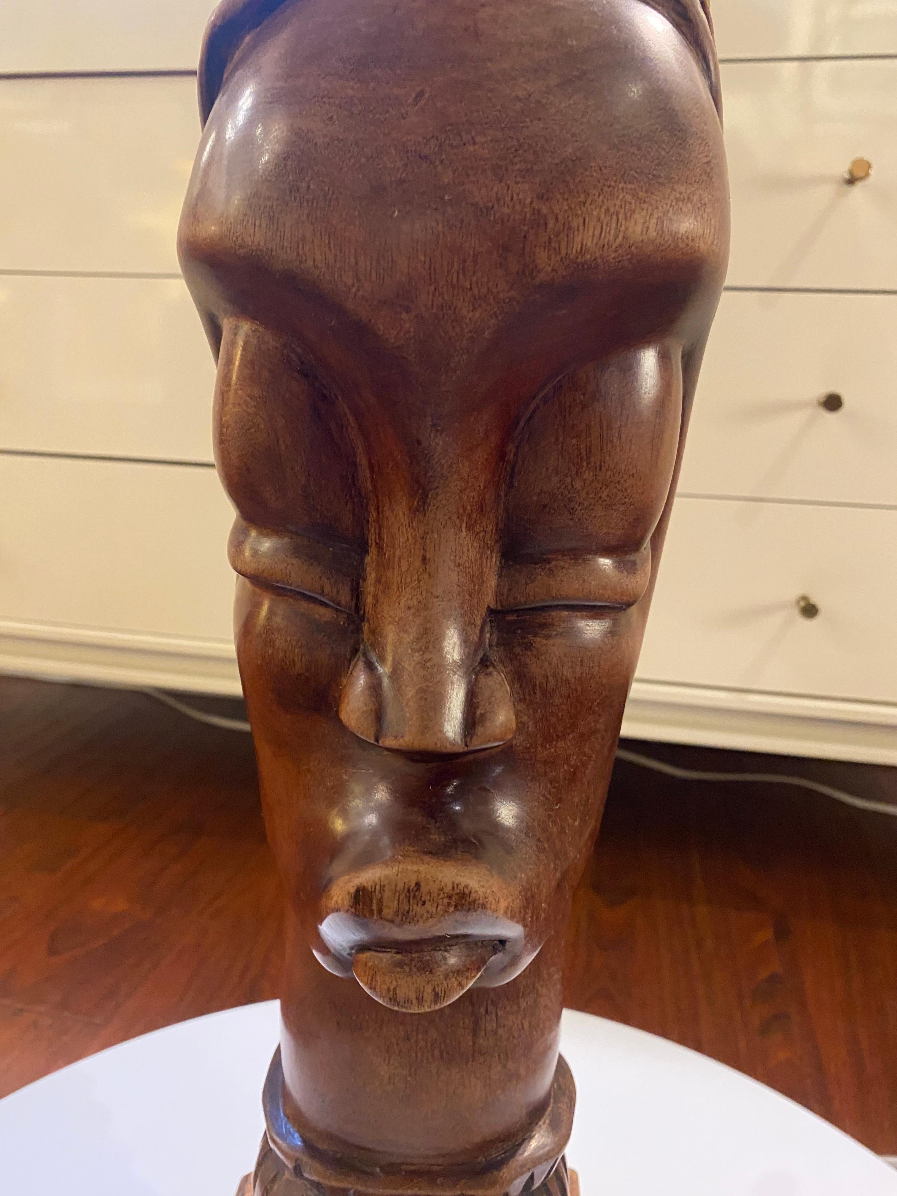 This wooden sculpture embodies hyper-verticality, a hallmark of many African sculptural traditions. Its elongated form eschews anatomical realism, instead striving to evoke a presence that transcends simple figuration. The face, with its stylized