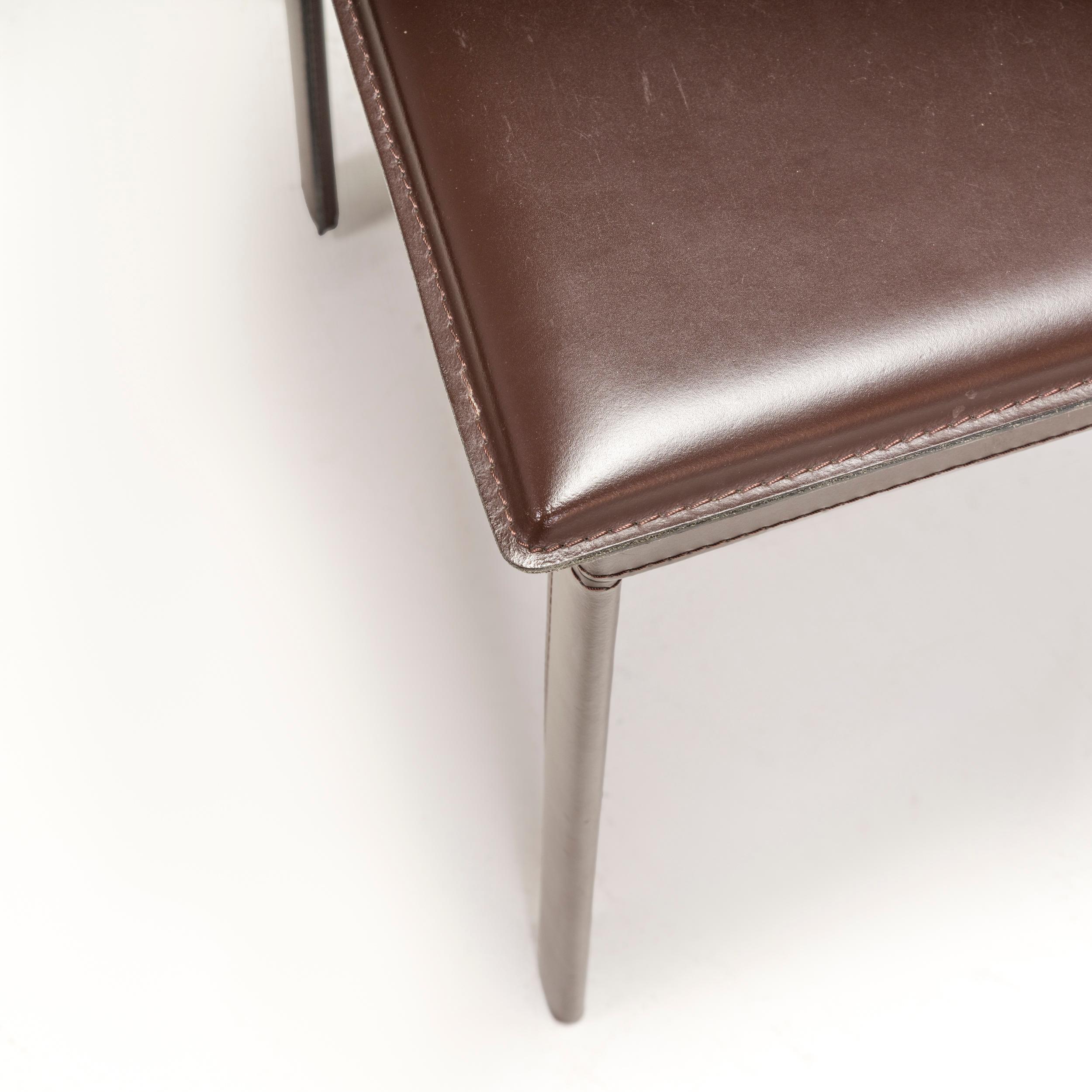 The Riva 1920 Dining Chair has a sleek, contemporary silhouette. The seat cushion is padded and upholstered in deep brown leather for additional comfort, and has a glossy finish that adds to its sophisticated style. Meanwhile details such as the
