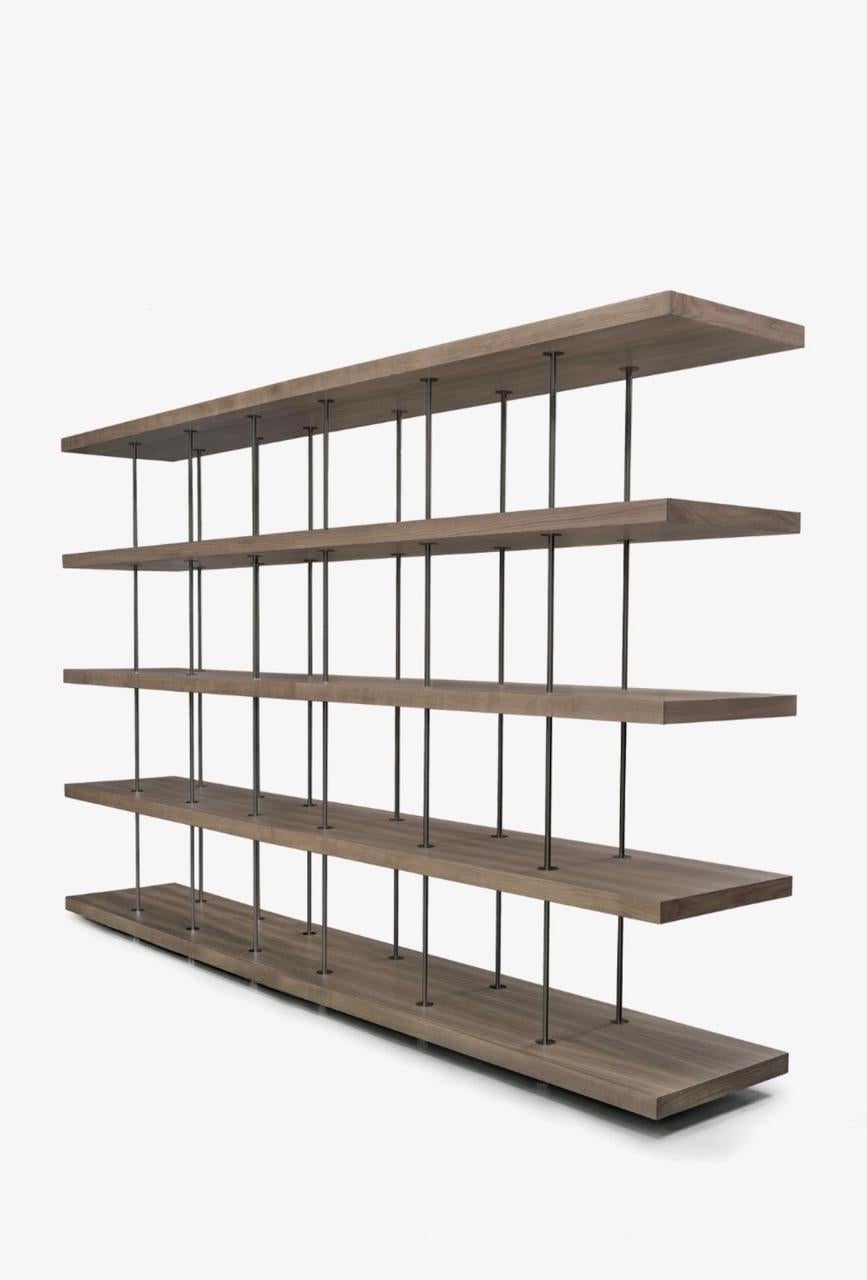 The impressive bookcase created by Renzo and Matteo Piano showcases a remarkable equilibrium between solid and empty spaces. Connected by just six pairs of stainless steel rods, it achieves a genuinely open and airy appearance. Its five spacious
