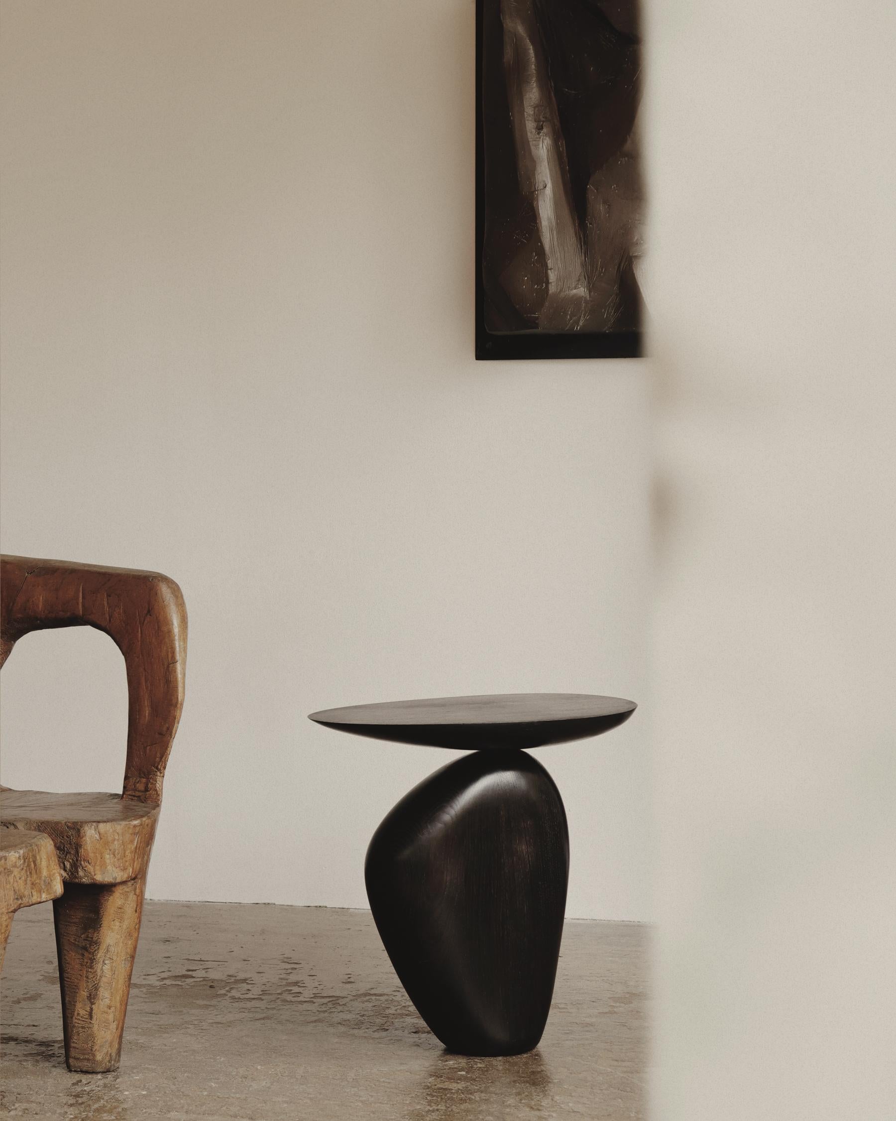 Rive oak side table by Homefolks
Dimensions: D 32.5 x W 50 x H 50 cm 
Materials: oak wood

An exercise of balance, the Rive side table is composed of two sensuous, organic wood forms. Evoking stacked pebbles, its bold and sculptural shape echoes